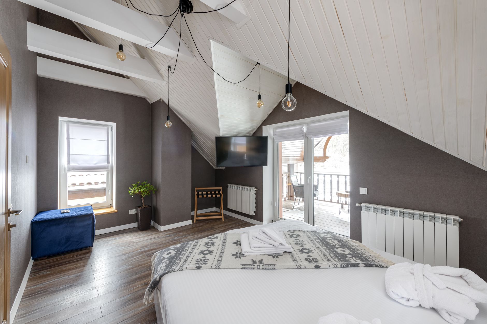 Modern hotel room featuring stylish decor, a balcony, and a spacious layout.