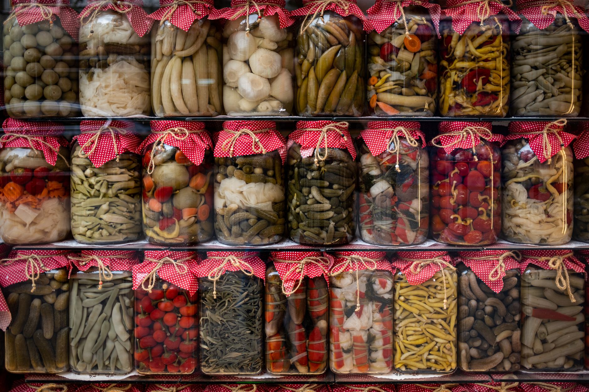 Homemade jars of assorted pickles and preserves arranged on a shelf in Turkey.