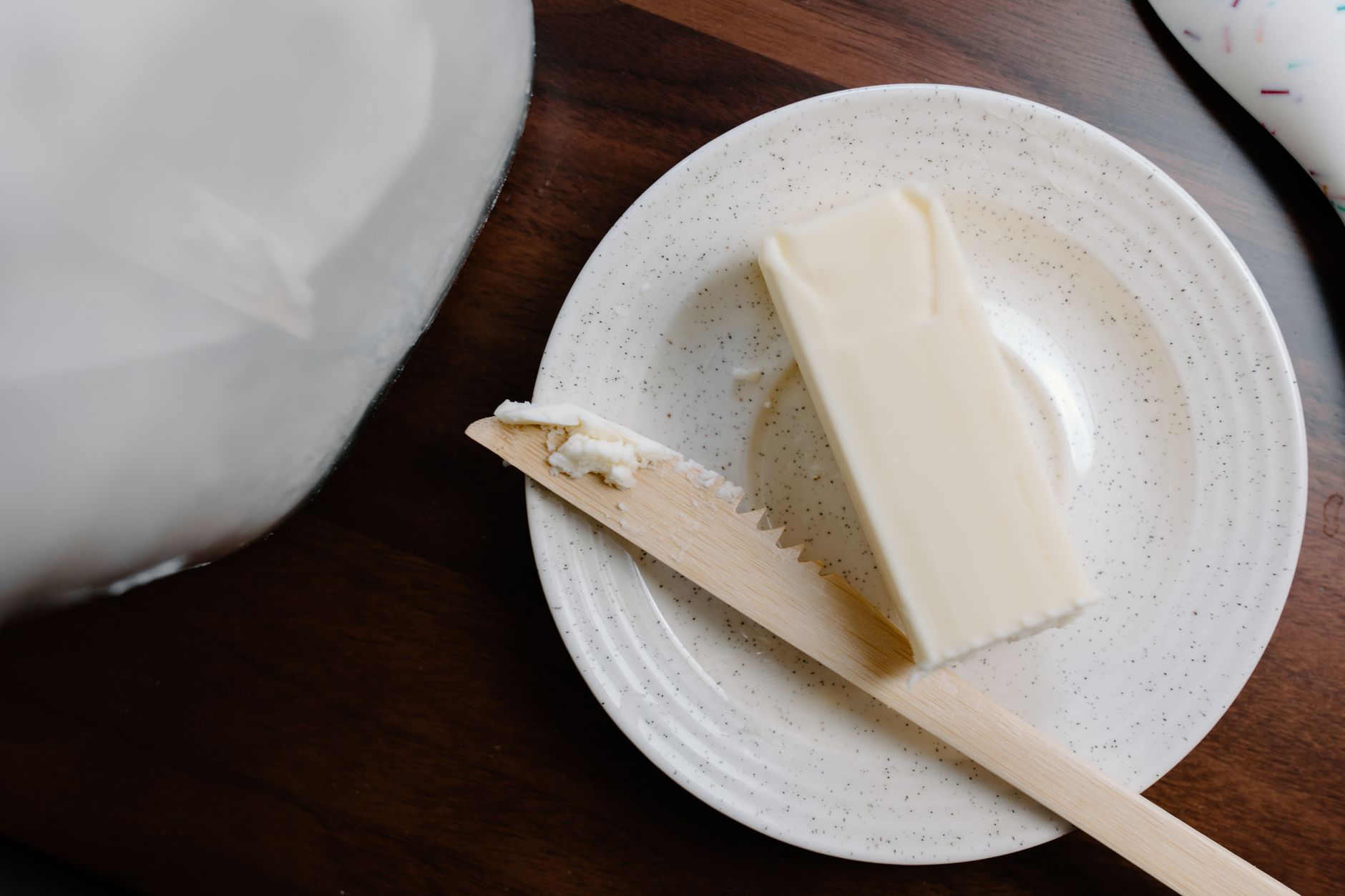 A plate with fresh homemade cheese and butter on a wooden table.