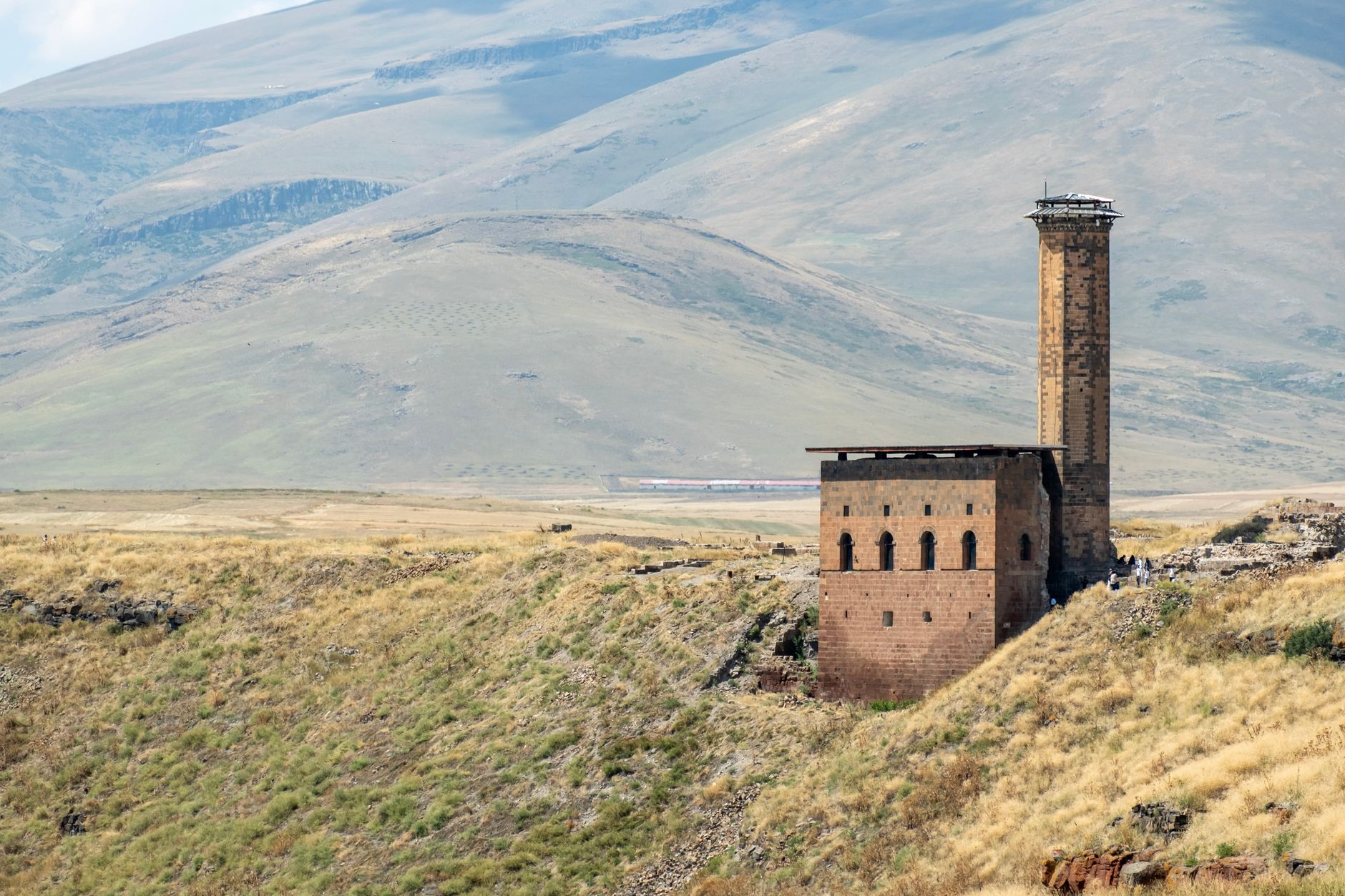 The ruins of Ani, a historical site in Turkey, featuring ancient structures against a mountainous backdrop.