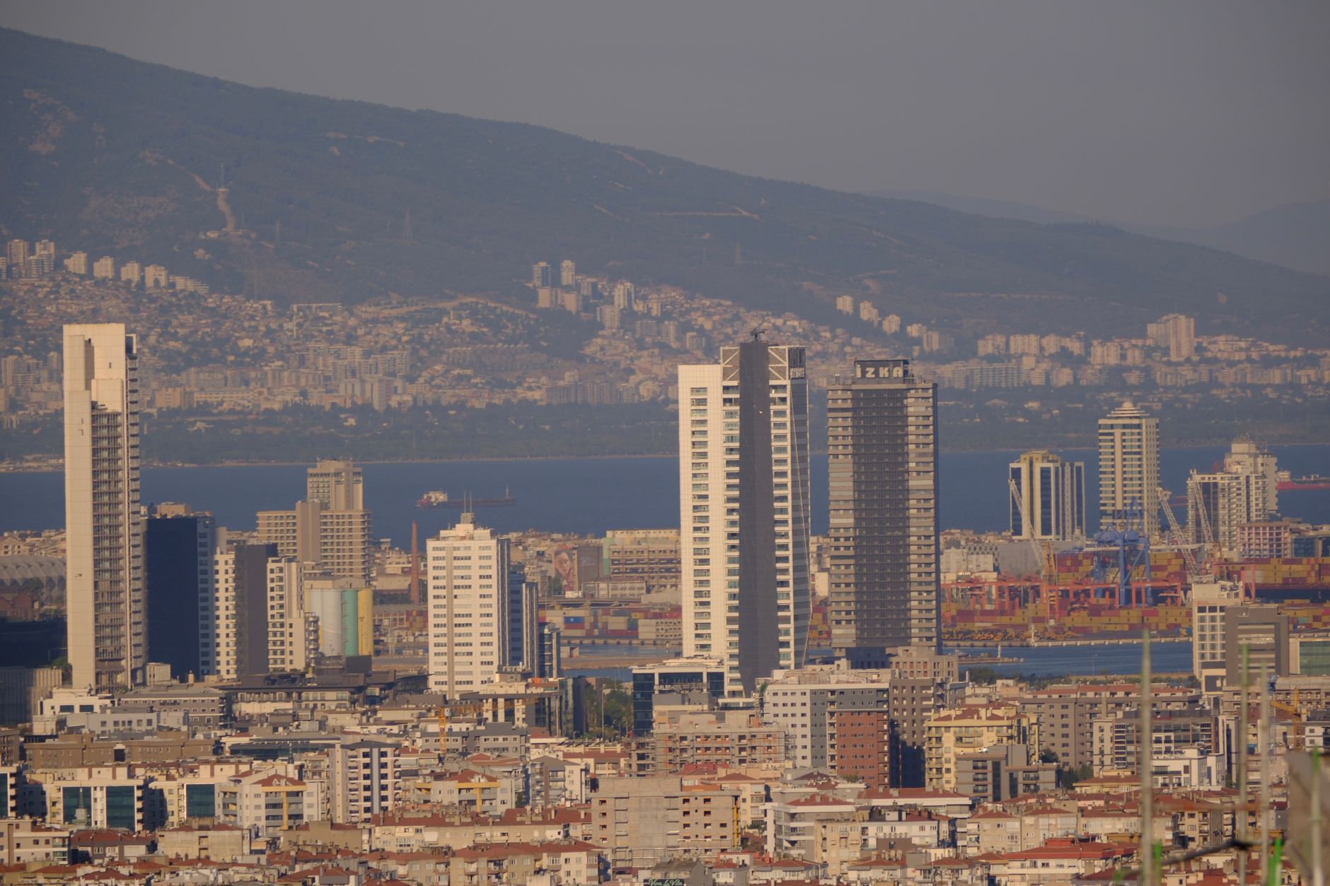 Aerial view of Izmir featuring modern skyscrapers and the Aegean coastline, showcasing its architectural landscape.