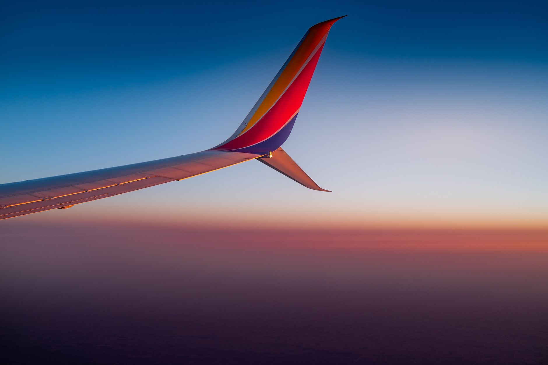 View of an aircraft wing with vibrant sunset colors, approaching Antalya.