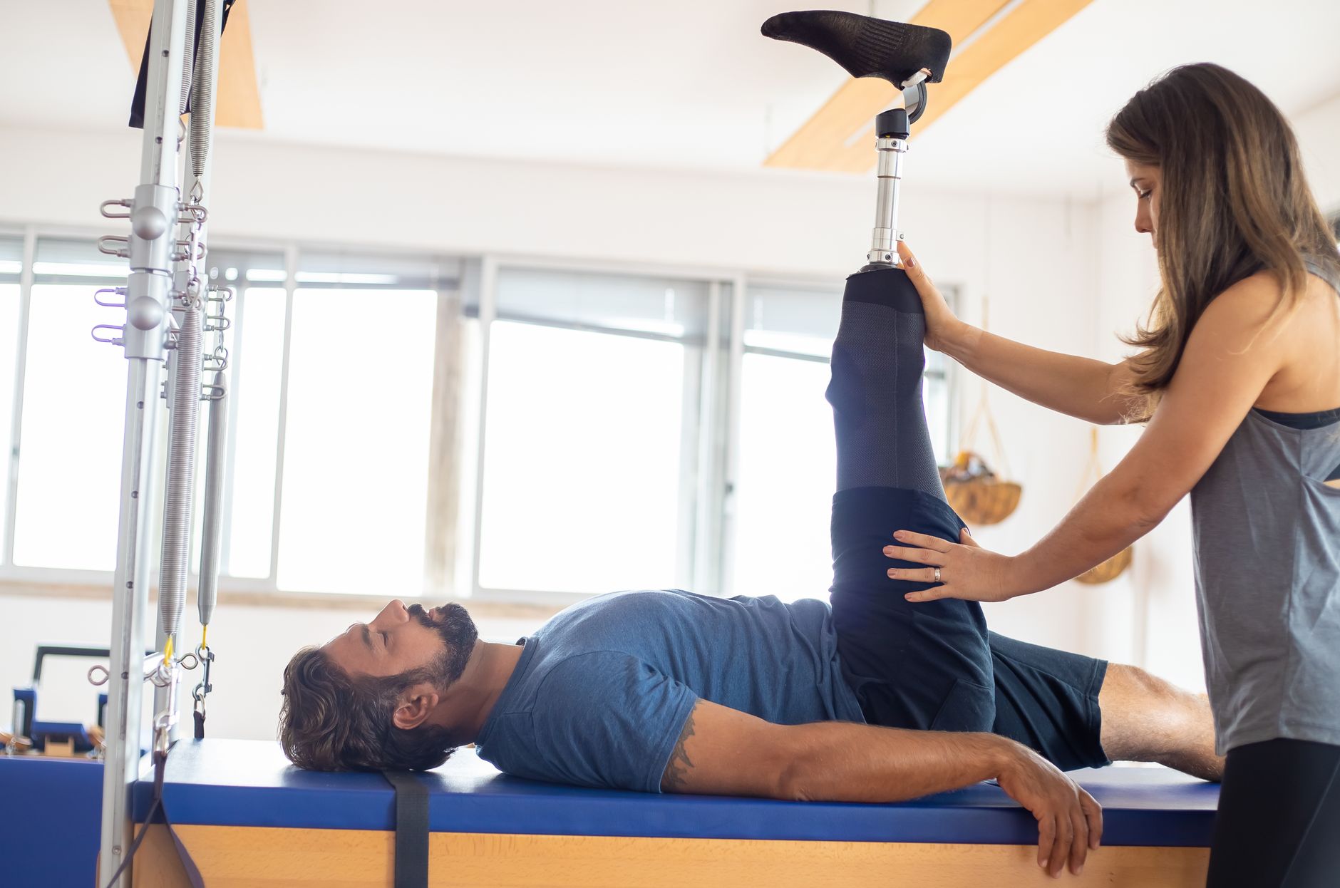 Patient with prosthetic leg receiving physiotherapy in a bright rehabilitation center.