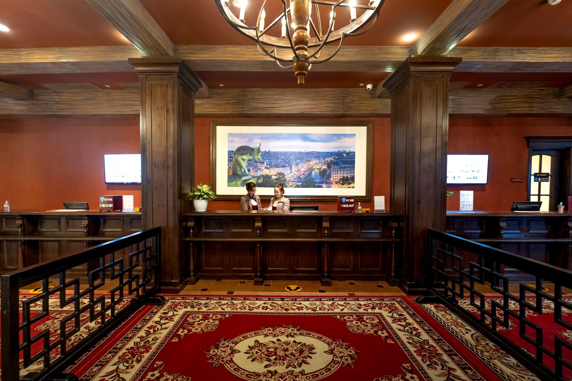 A stylish hotel lobby in Istanbul with two staff members assisting a guest at the check-in counter.