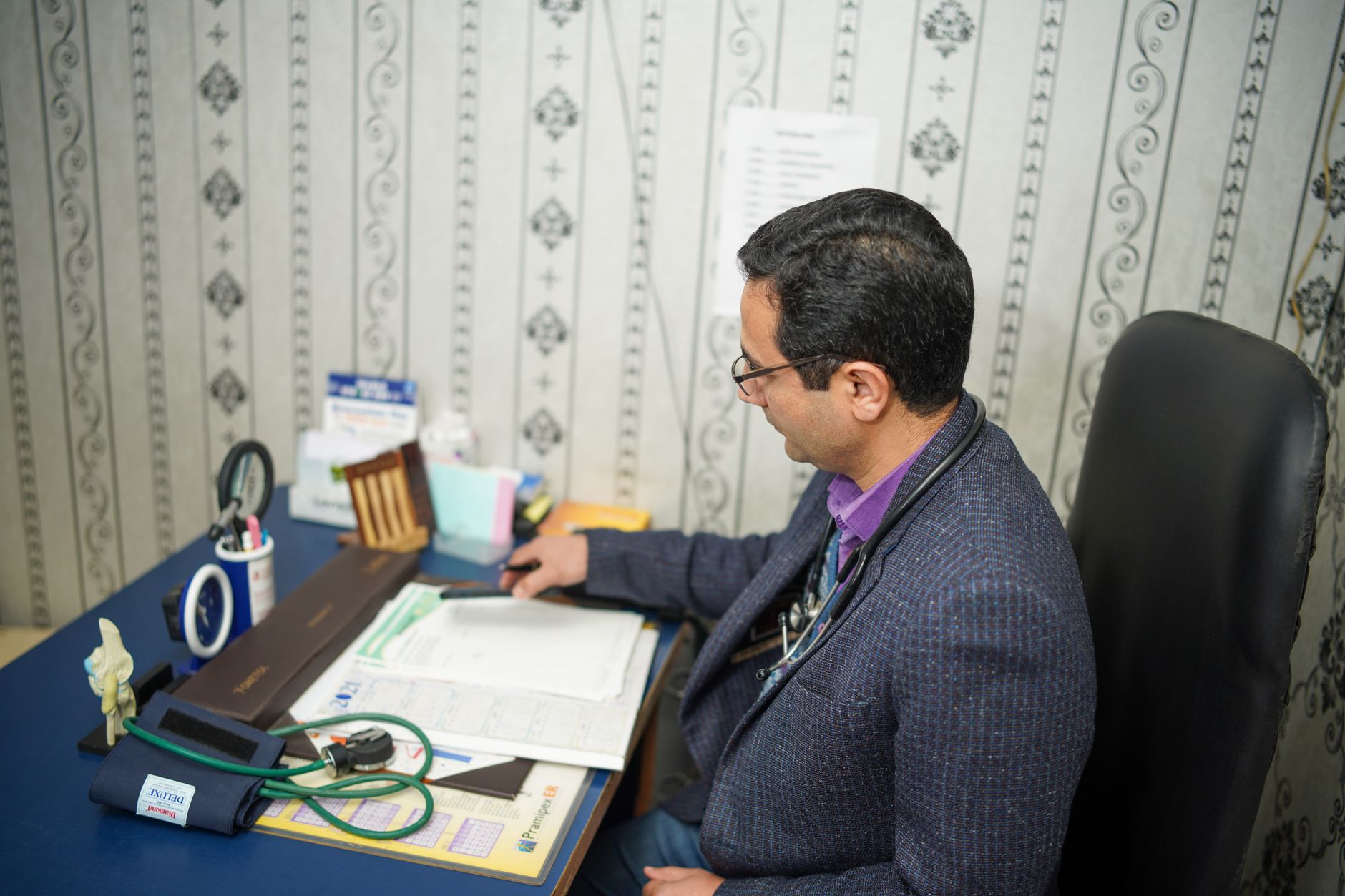A medical professional organizes records and reports at a desk, preparing for transfer to a Turkish bariatric centre.