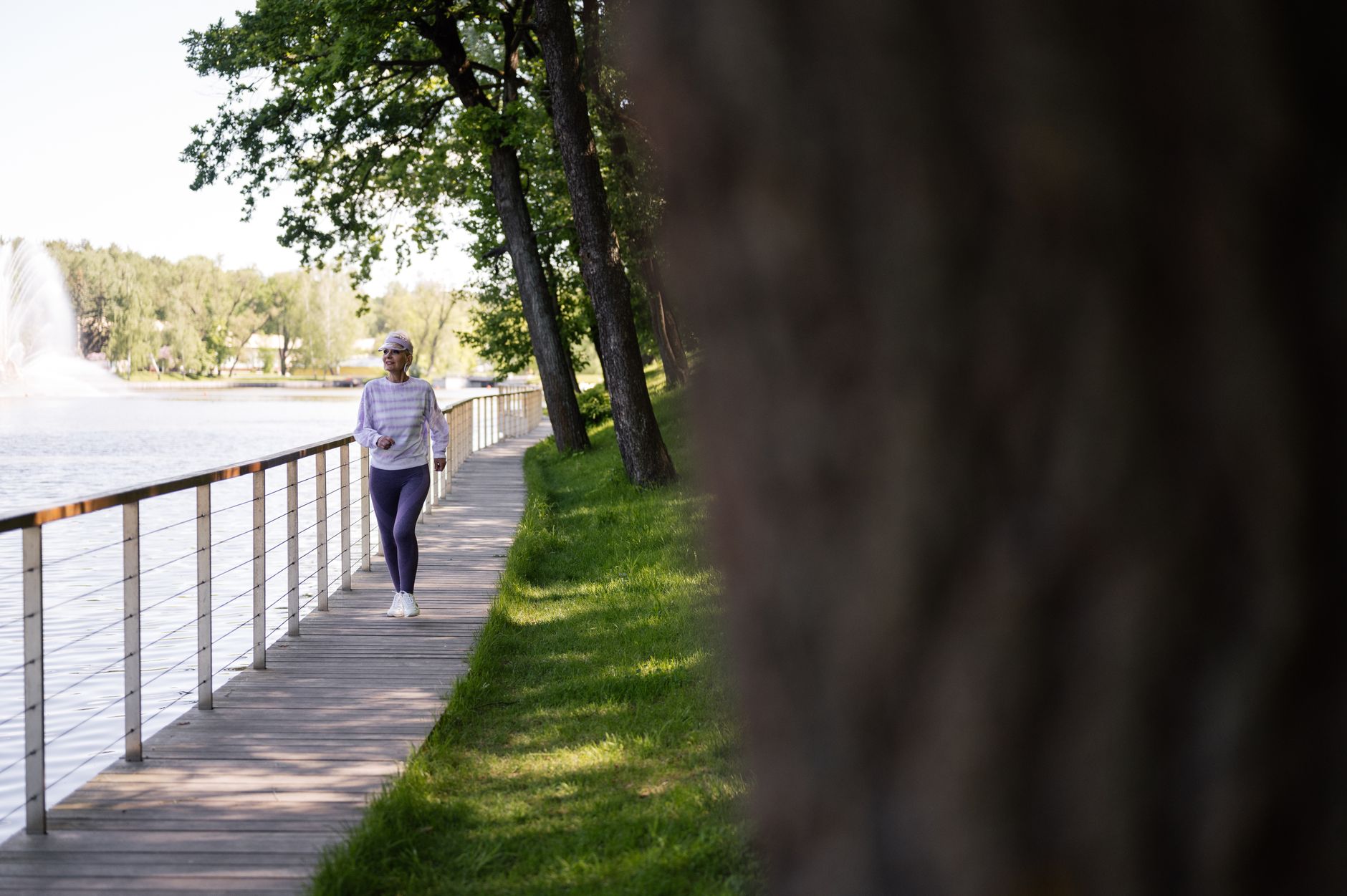 A woman enjoys a walk by the lake, embodying a healthy lifestyle post-weight-loss surgery.
