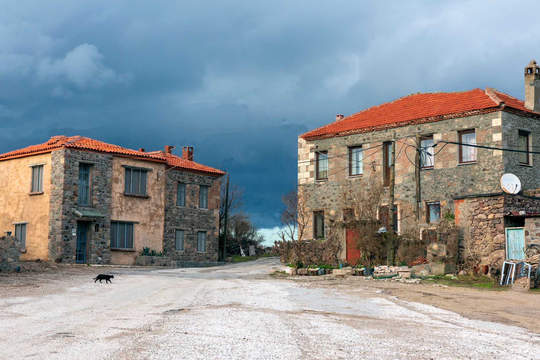 A picturesque scene of stone houses in a Turkish village with a cloudy sky.