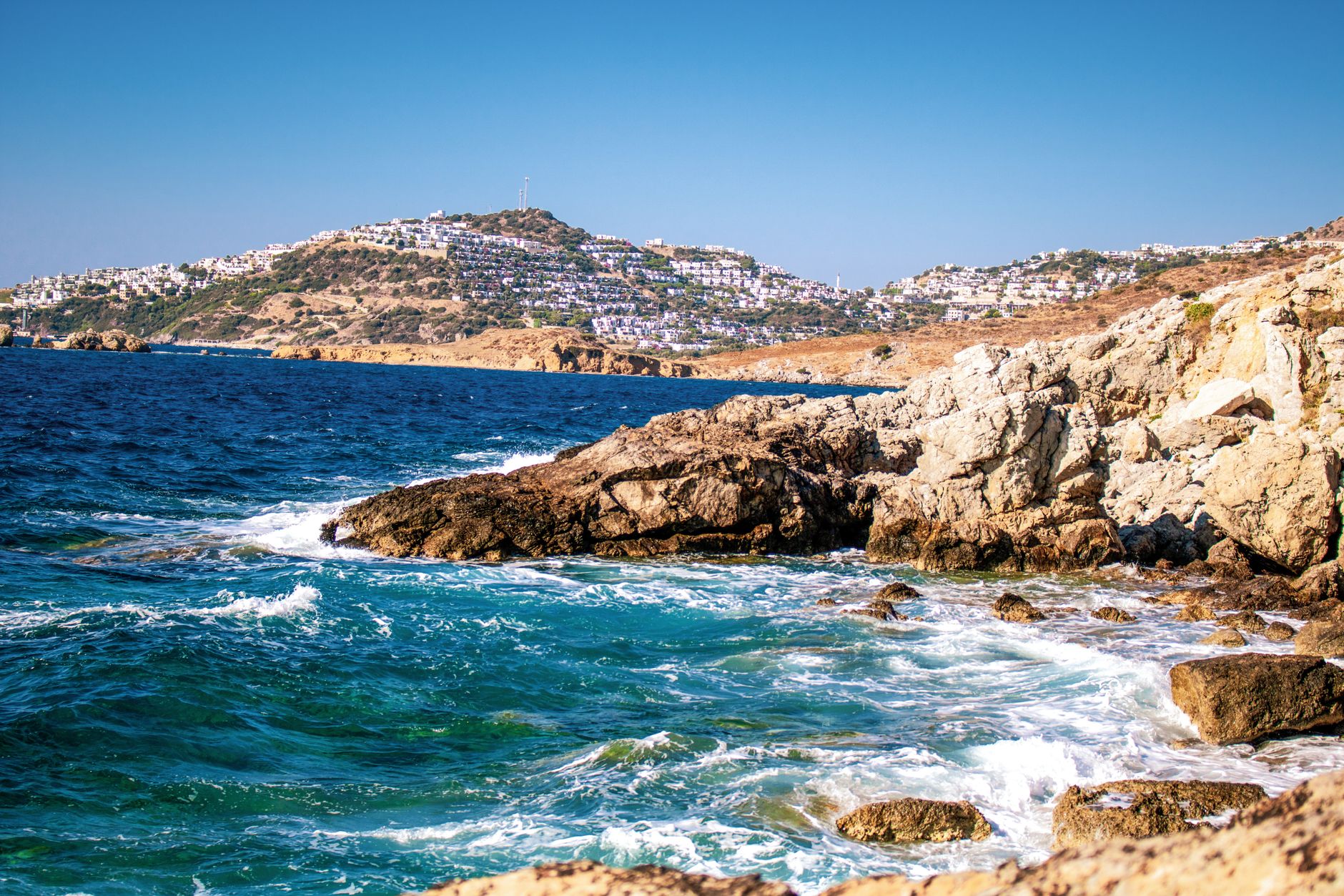 Bodrum'daki Kumbahçe Plajı'nın kayalık kıyıları ve berrak turkuaz sularıyla güzel manzarası.