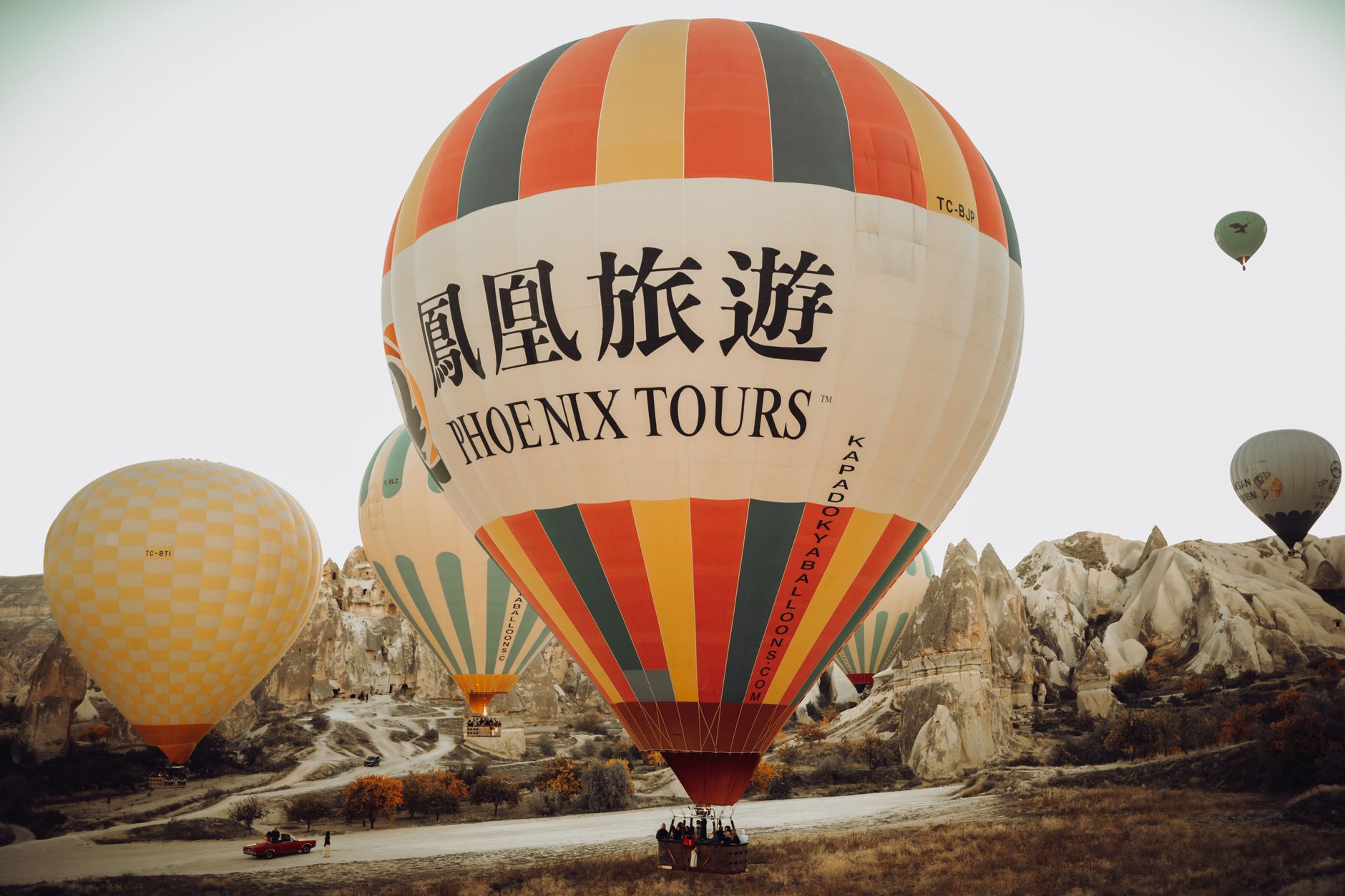 热气球吊篮中的乘客欣赏卡帕多奇亚景色，飞行员正在调节燃烧器。