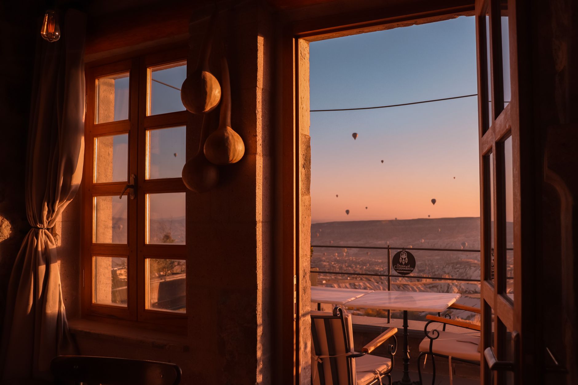 日出时分，石砌露台上的早餐，热气球在天空中飘浮。