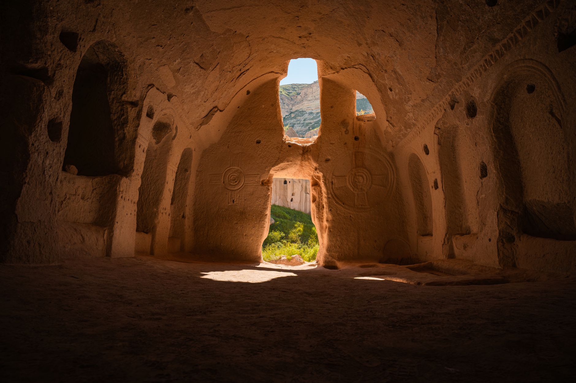 Interior view of a carved tunnel in Derinkuyu, showing arches and light streaming in.