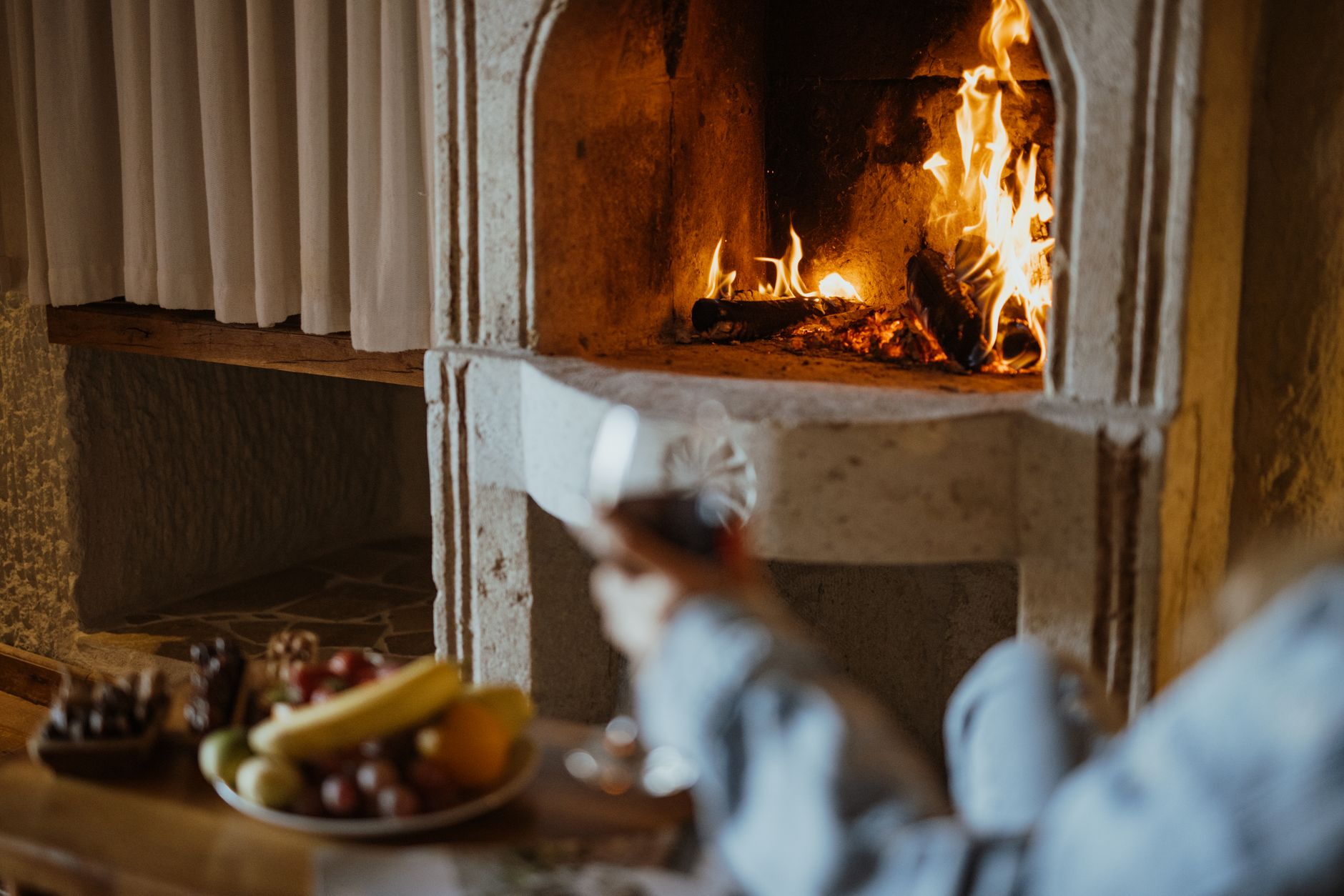 Warm ambiance of a cave hotel in Cappadocia featuring a stone fireplace.