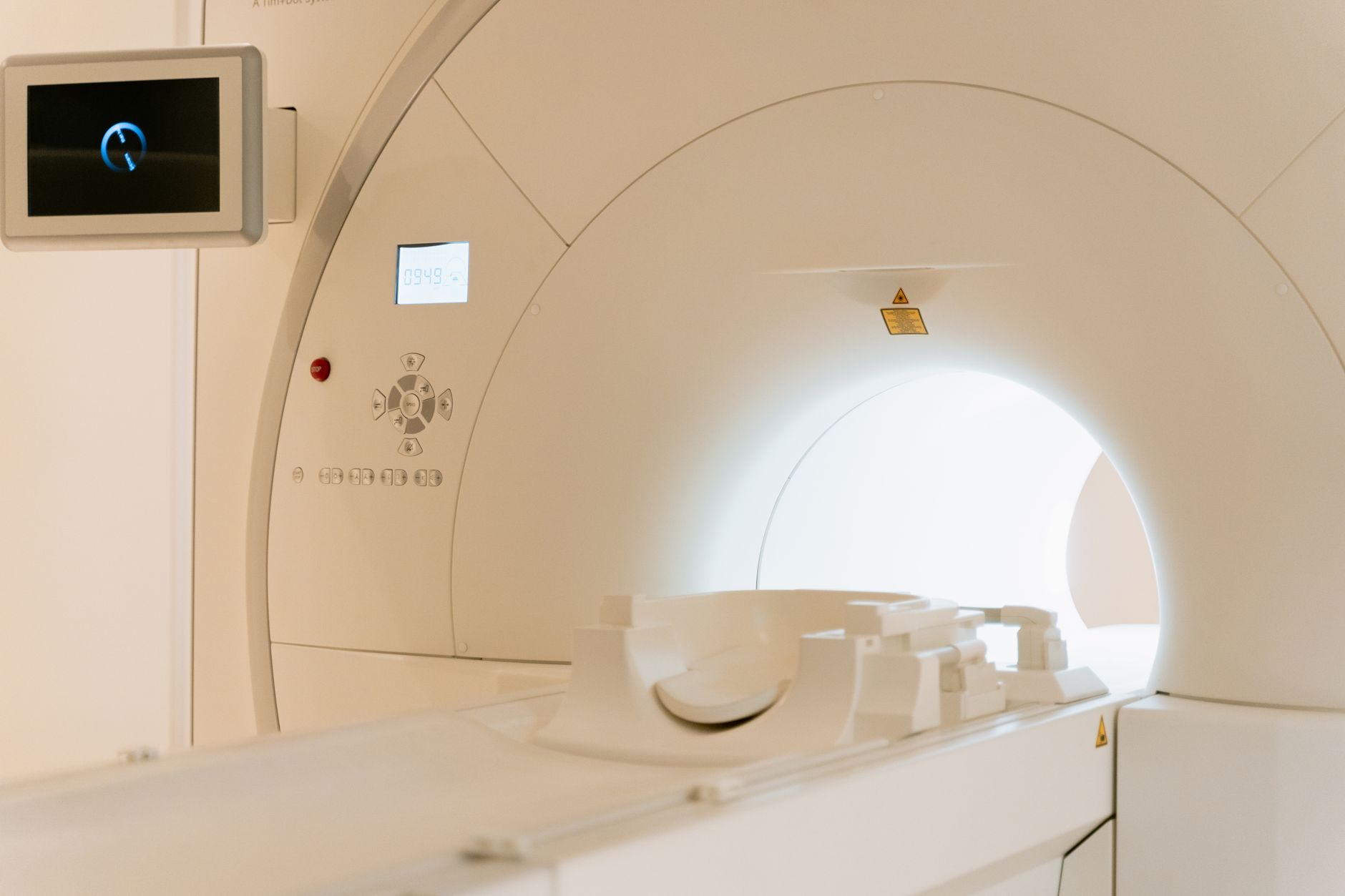 Close-up of an MRI machine with a control panel in a hospital setting.