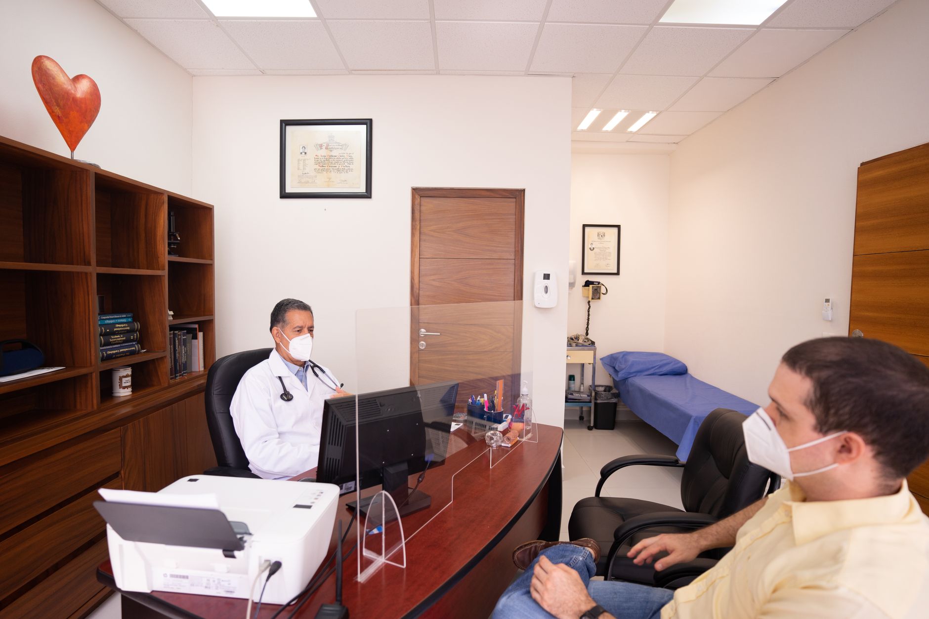 A cardiologist discusses heart health with a patient in a clinic office.