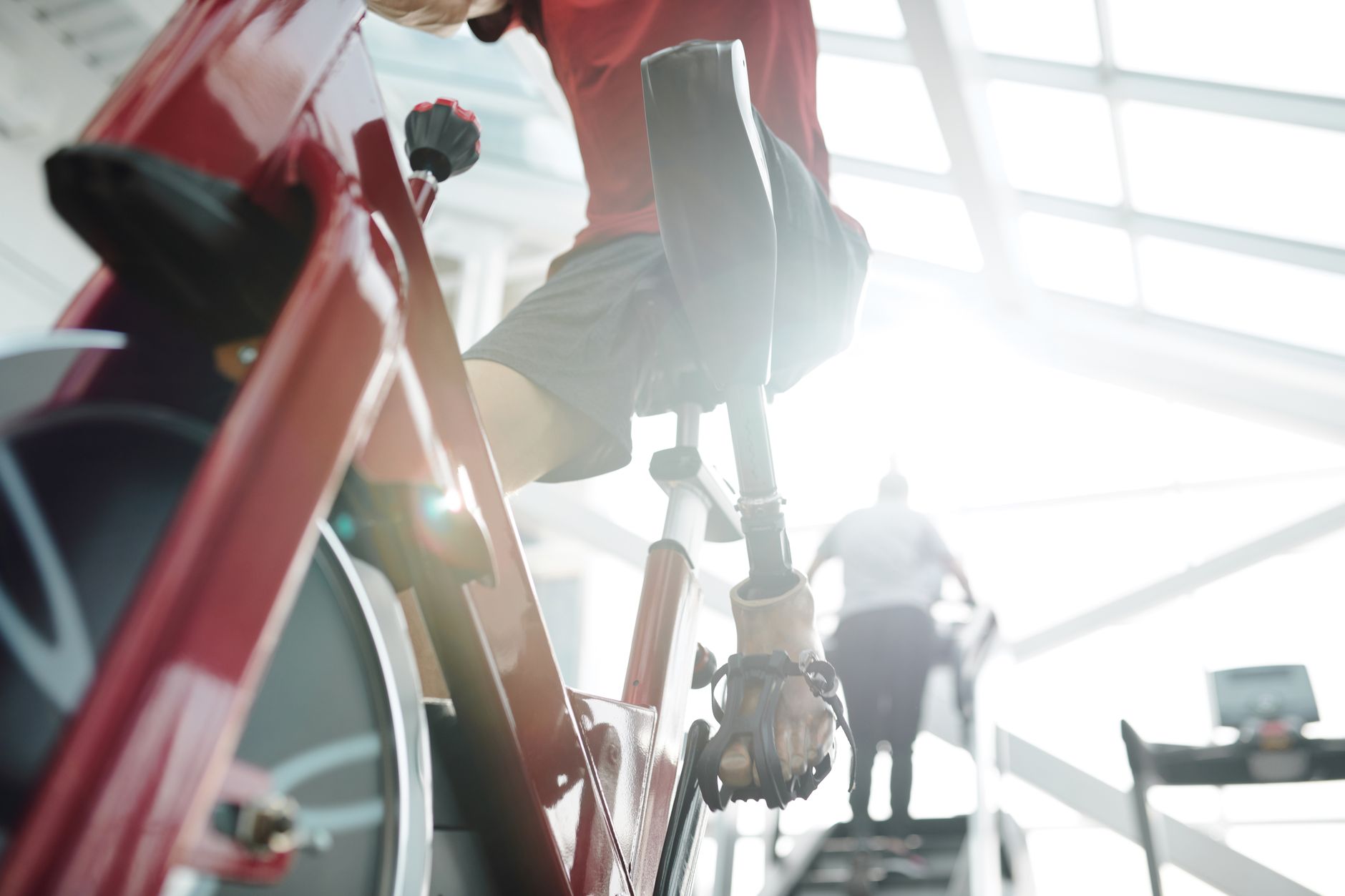 A patient with a prosthetic limb exercises on a stationary bike during cardiac rehabilitation.