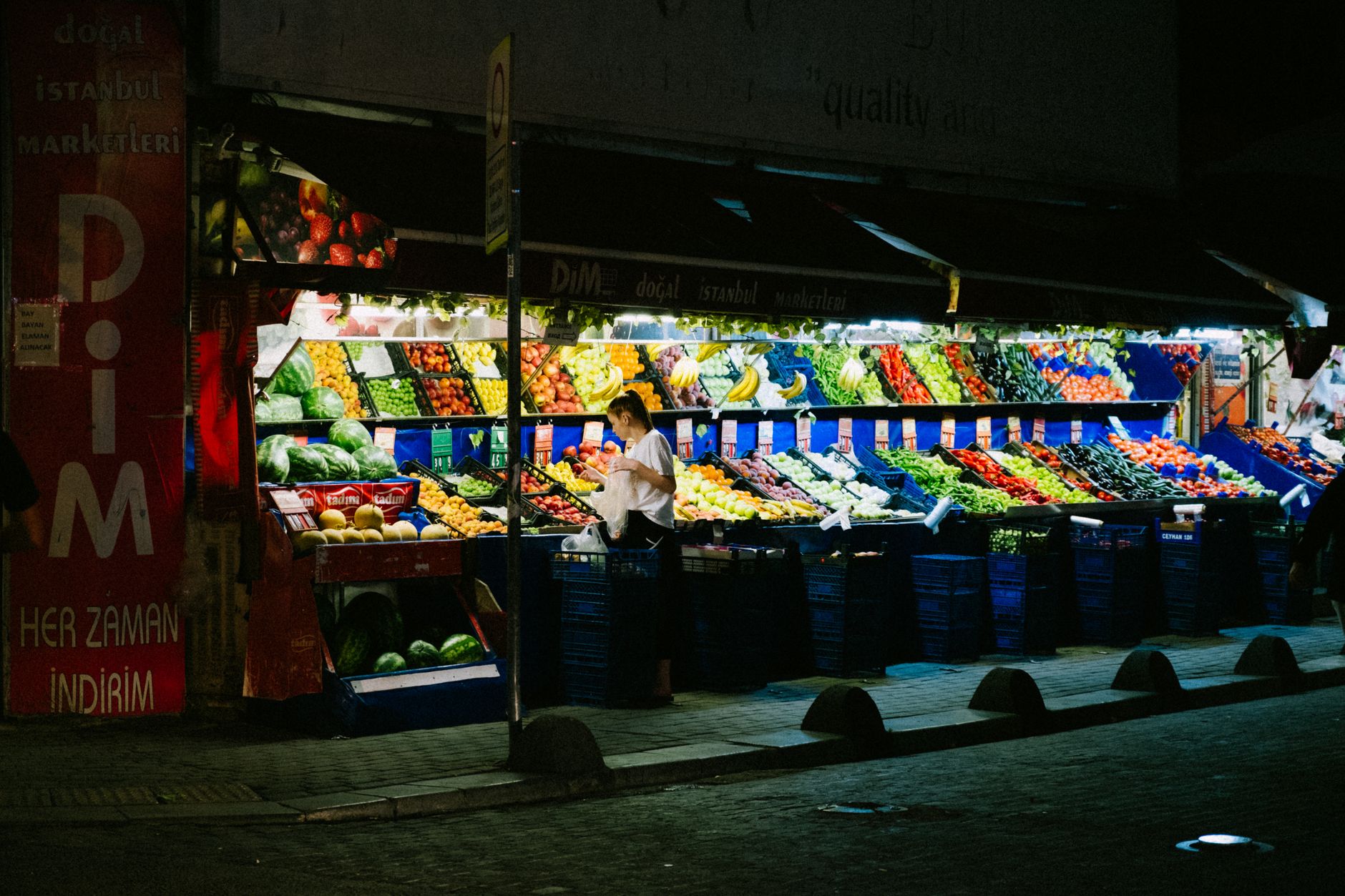 A bustling market in Istanbul with stalls full of fresh fruits and vegetables, and shoppers browsing.