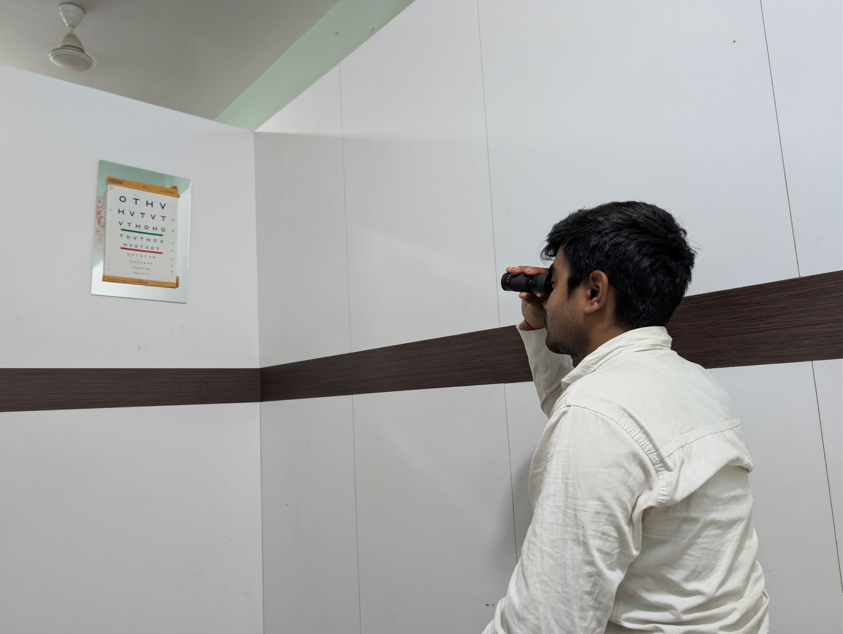 Individual using a visual field test device in a clinical room.