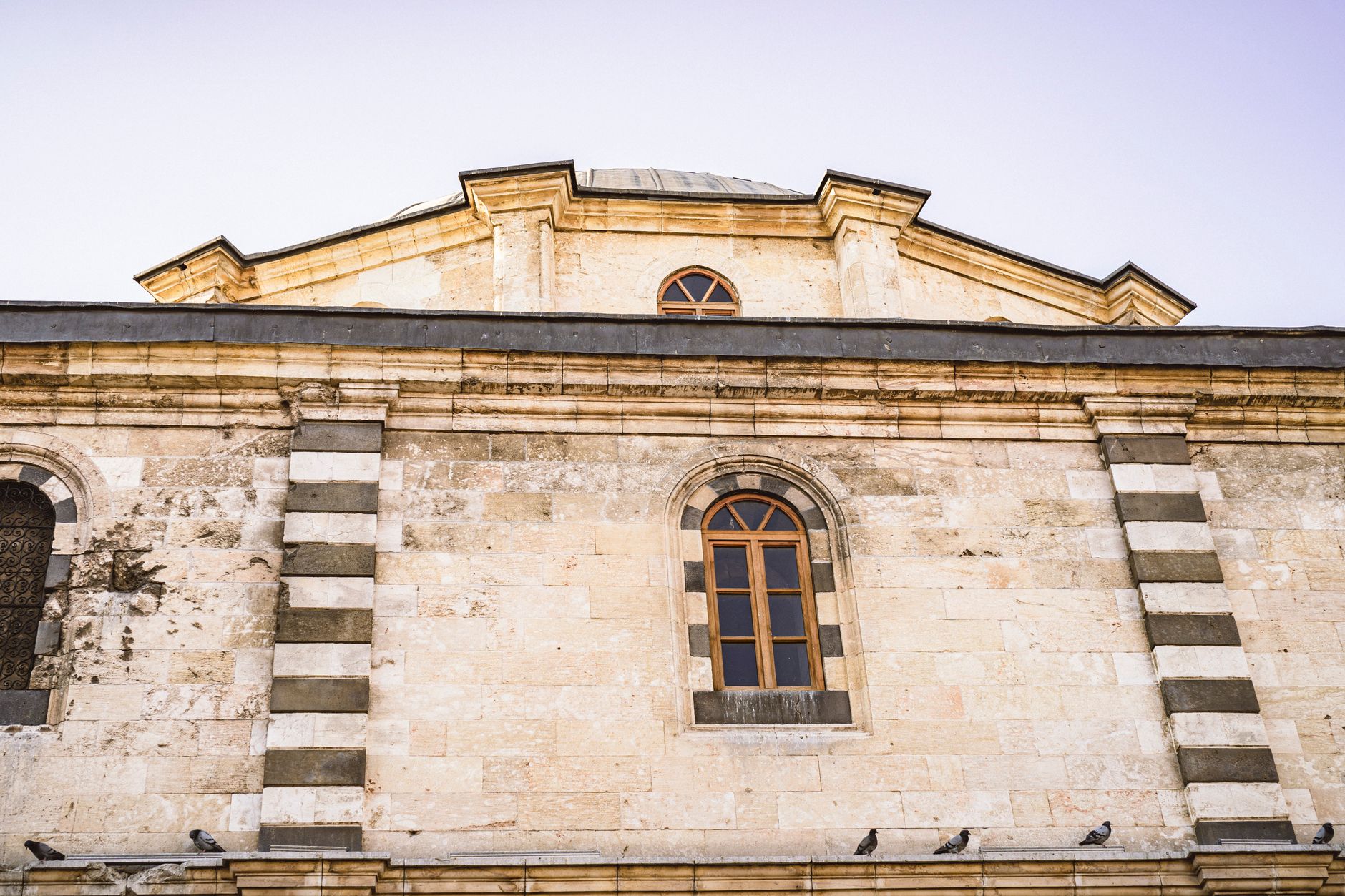 Detail of a historic building in Gaziantep featuring ornate windows and stonework.
