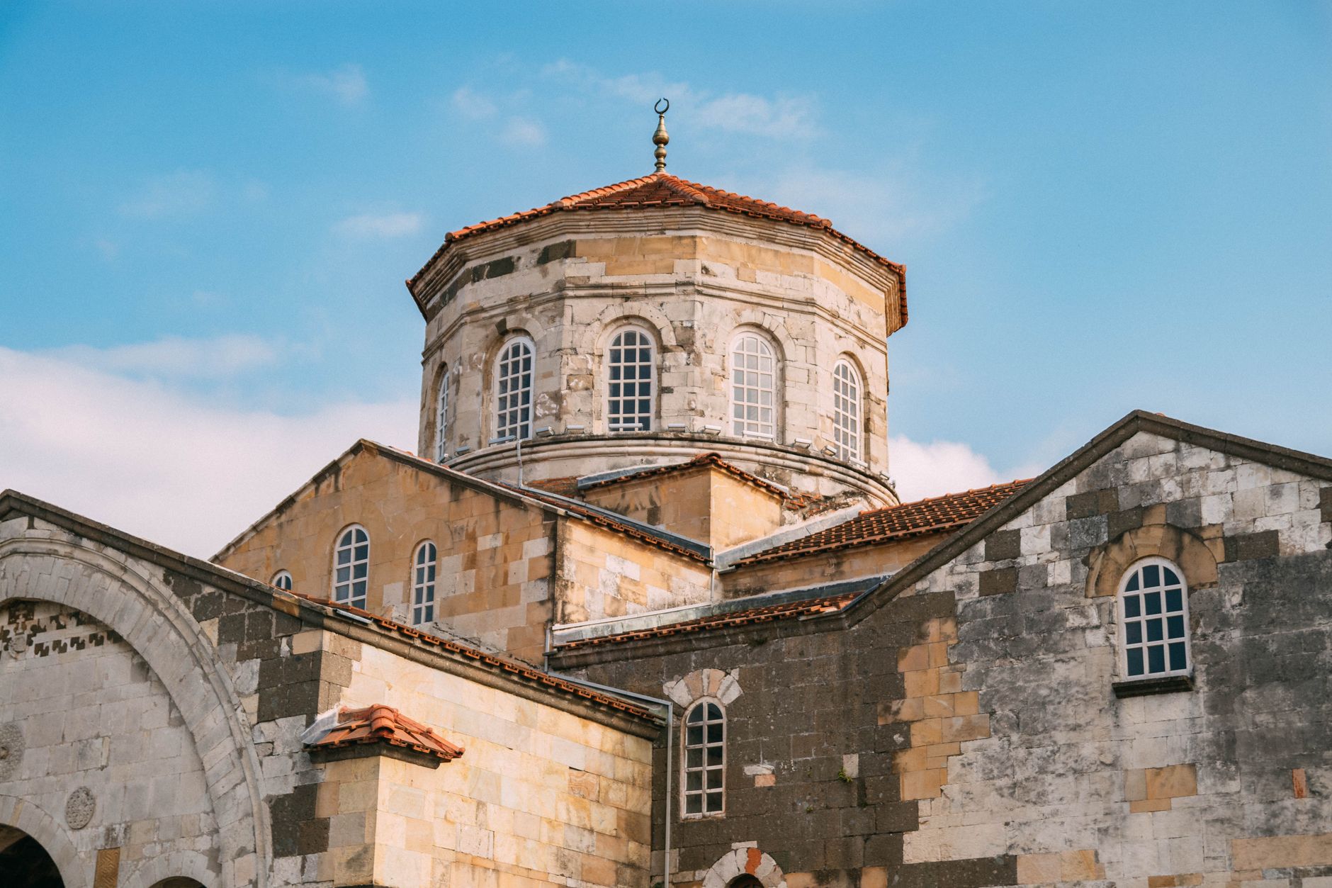 View of the Hagia Sophia in Trabzon, showcasing its unique architecture and dome under a clear blue sky.