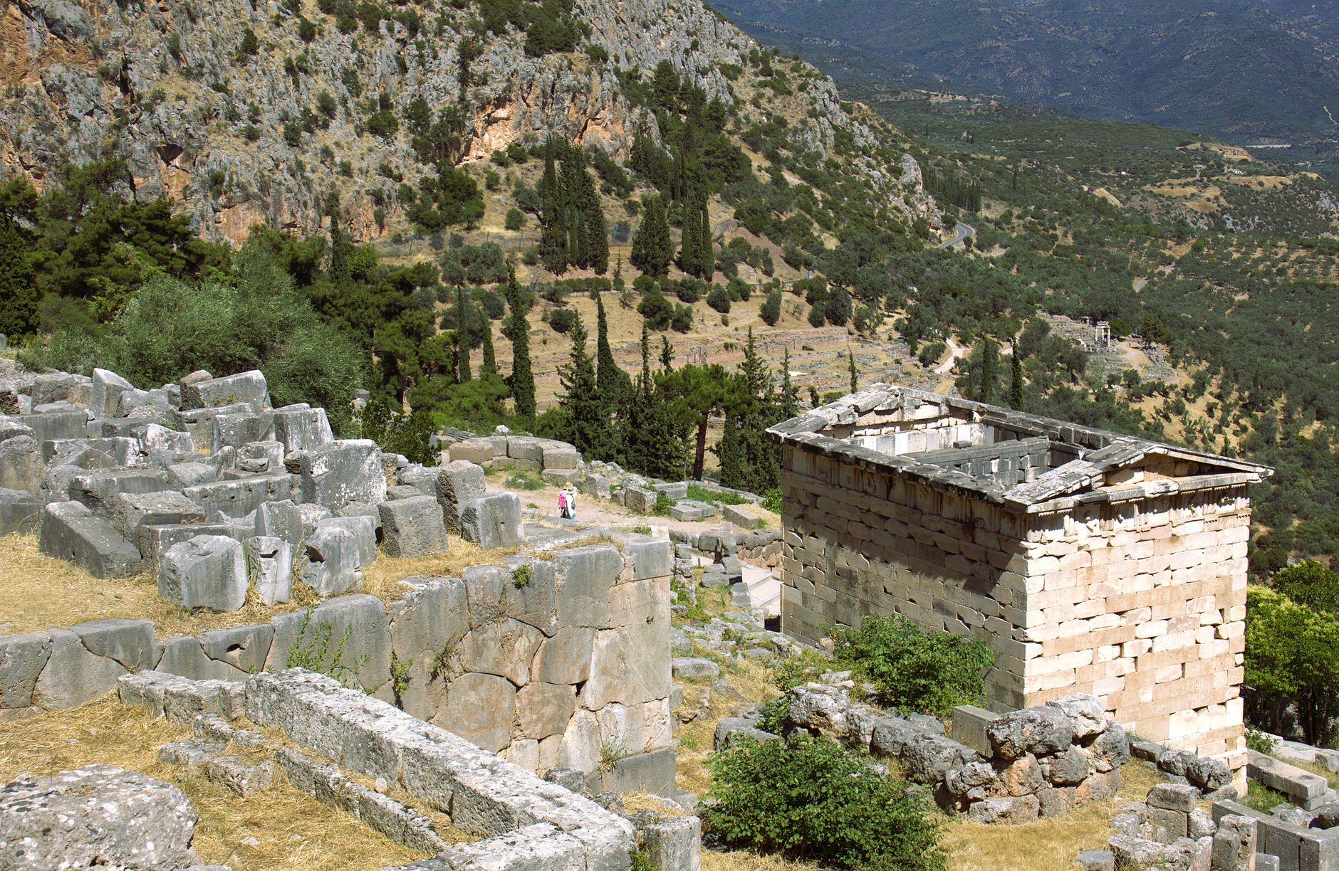 Priene'deki antik harabelerin görünümü; yamaç tapınağı ve tiyatro, yemyeşil dağlarla çevrili.