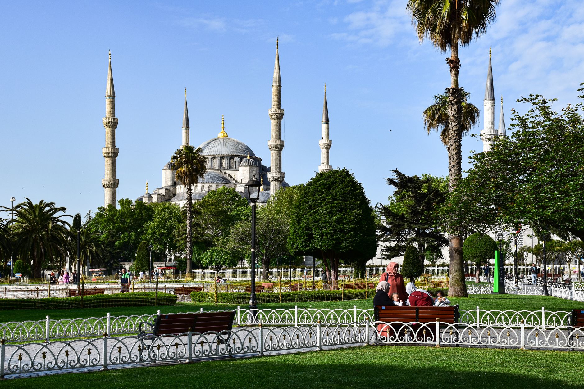Family enjoying leisure time in a park in Istanbul, with a beautiful mosque in the background.