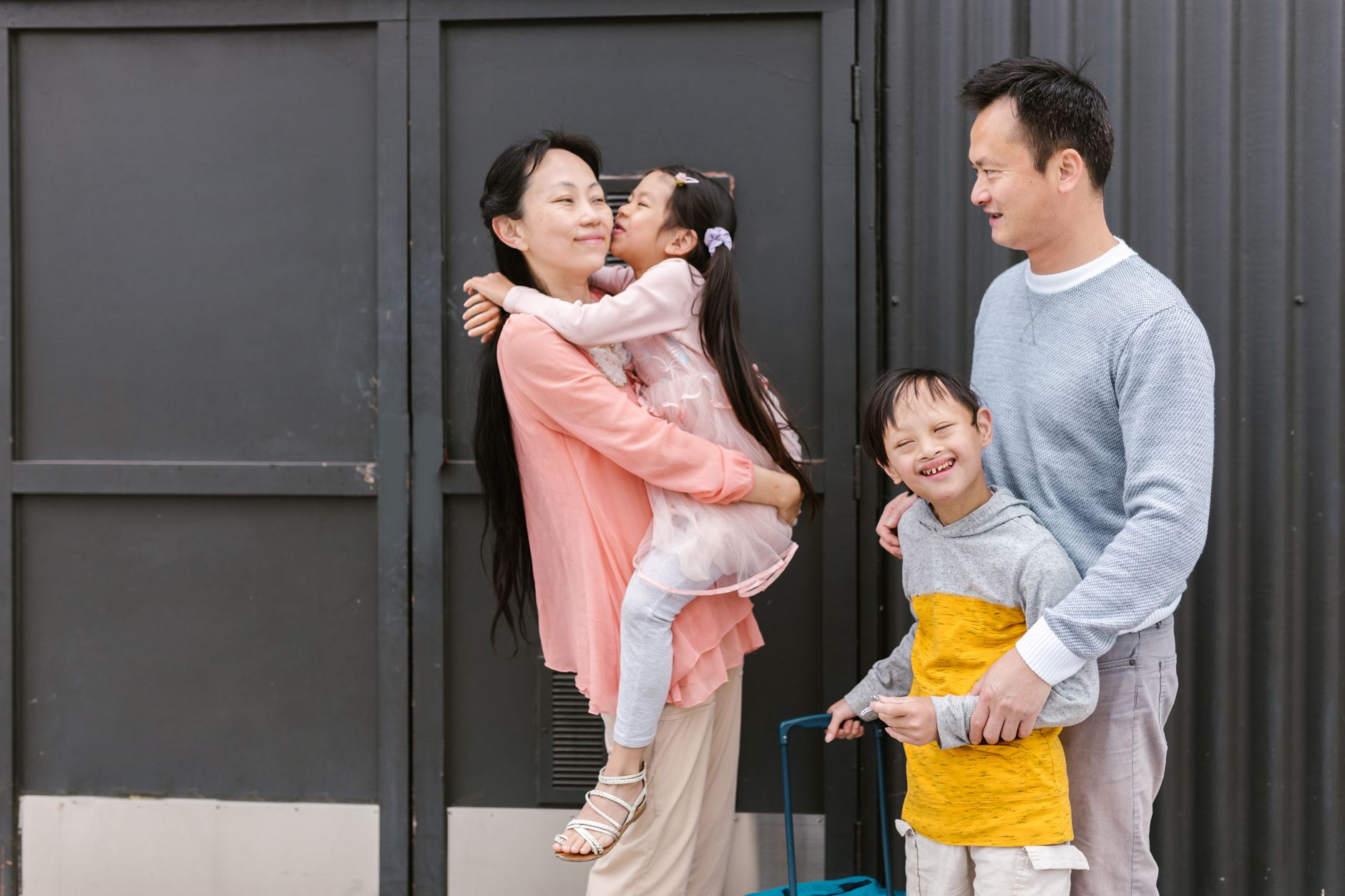 A joyful family outside, with a parent holding a child, promoting connection and therapy.