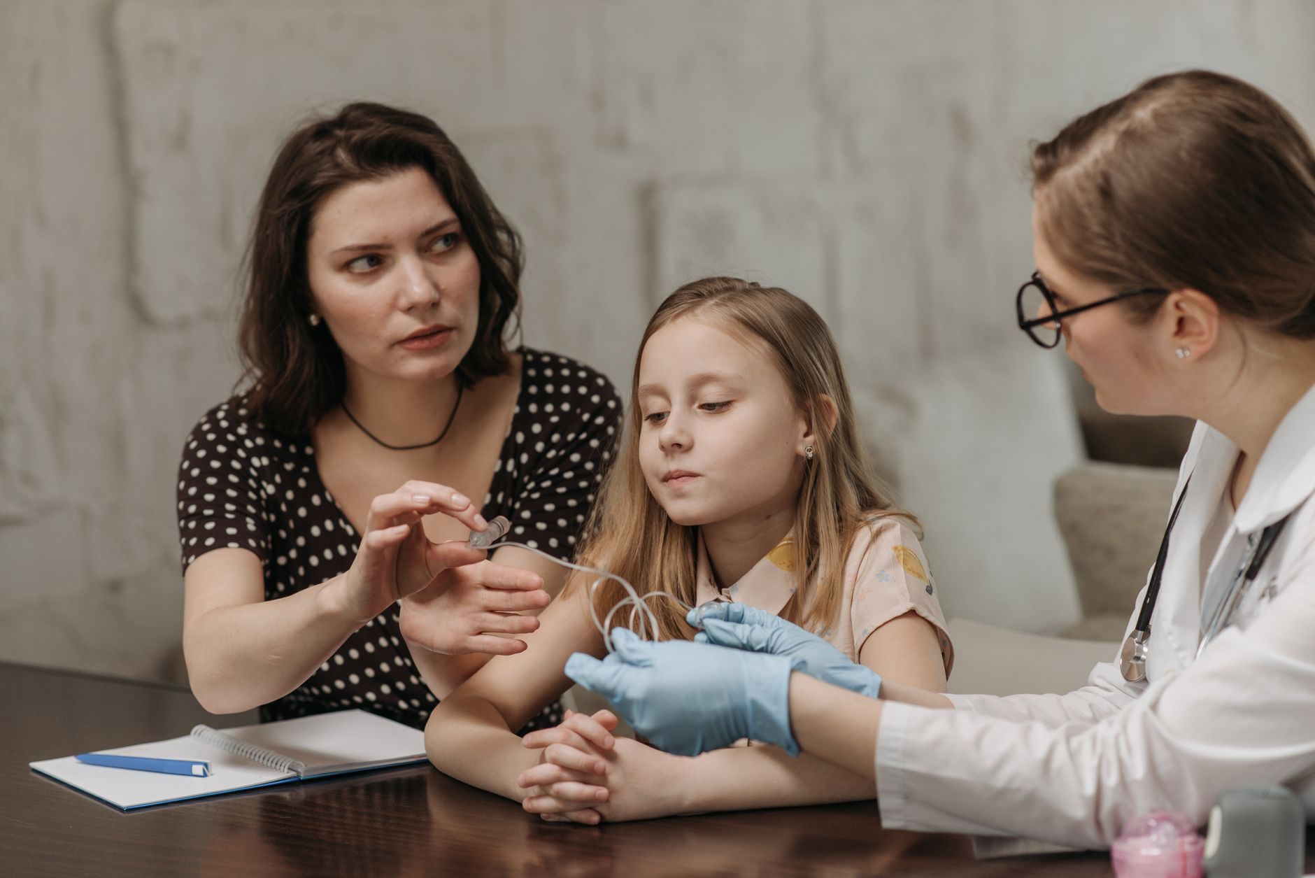 A mother discusses cochlear implant options with her child and a doctor.