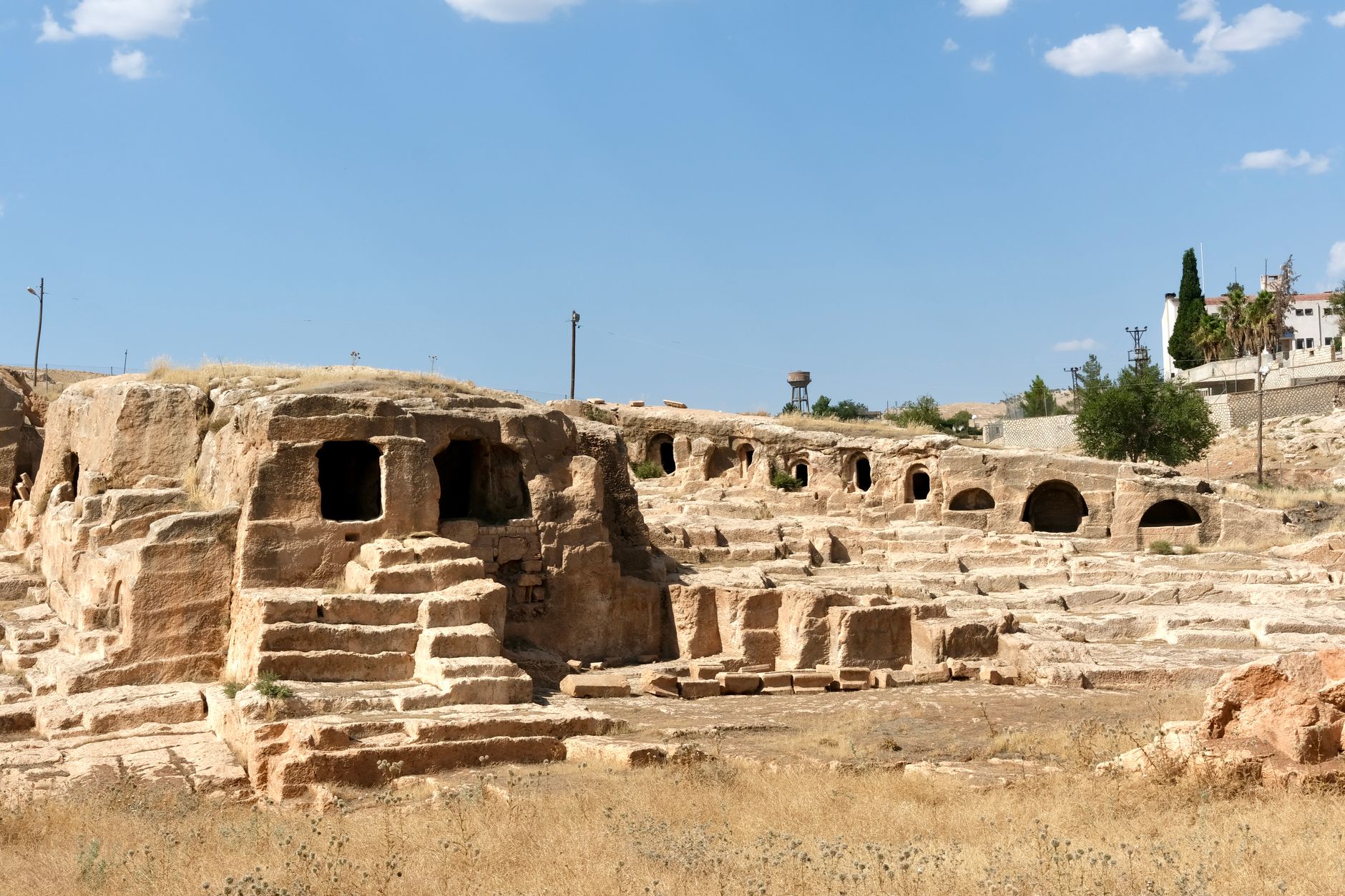 View of ancient ruins with steps and openings under a blue sky.