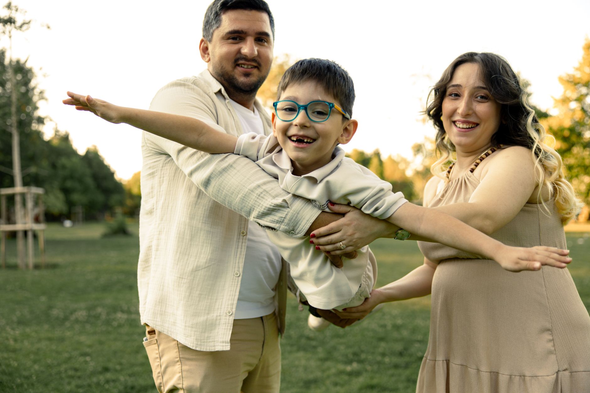 A family joyfully playing outdoors, celebrating a child's hearing care journey.
