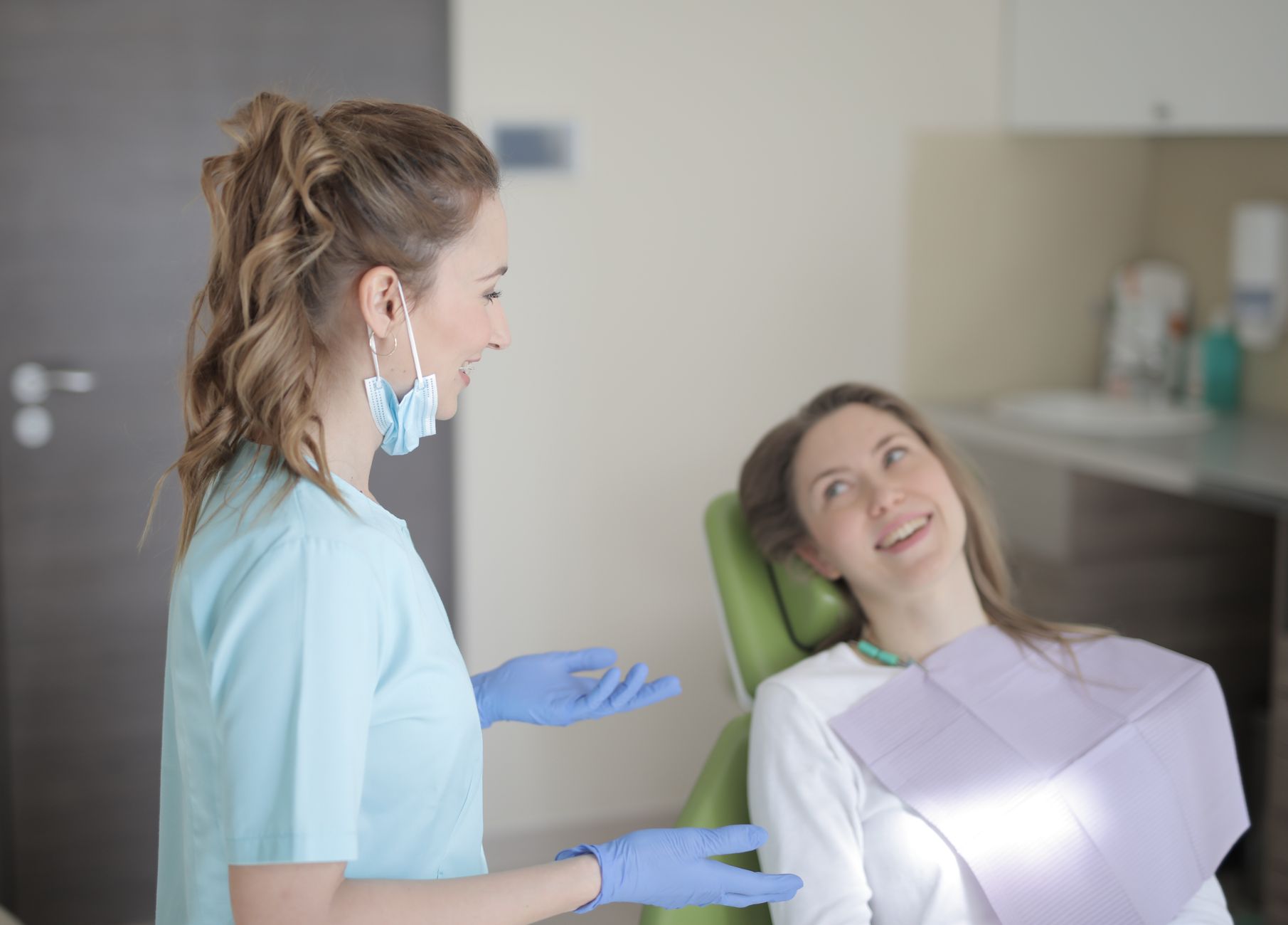 A smiling dentist talks to a patient in a Turkish dental clinic, showcasing a welcoming atmosphere.