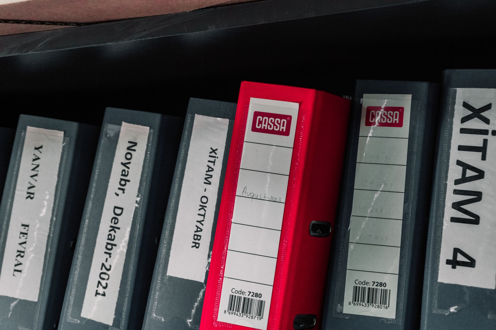 A neatly arranged shelf of discharge folders, including reports and a prescription list.