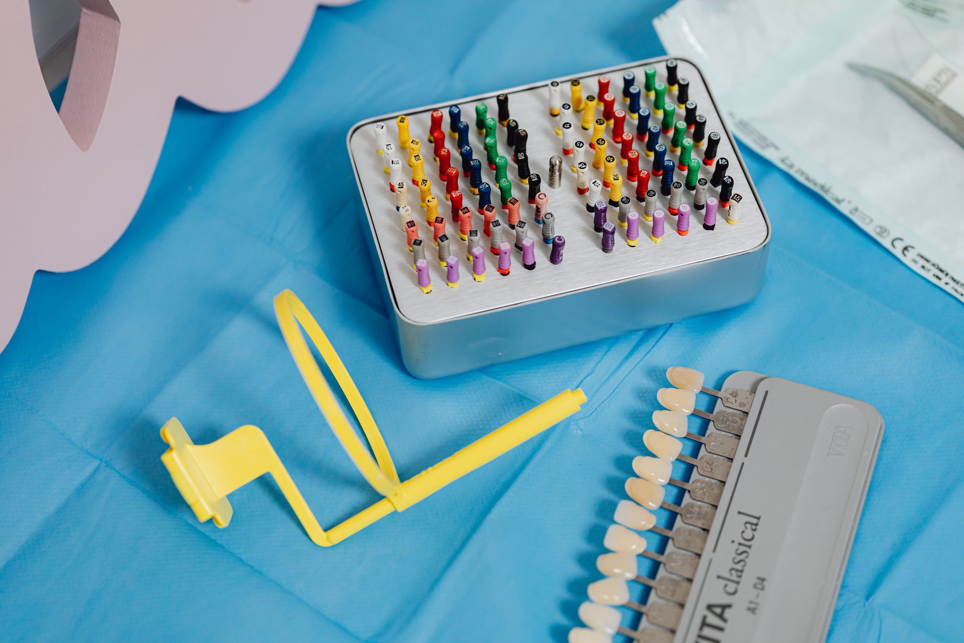 A set of dental restoration tools including color-coded pins and shade guides on a blue surface.