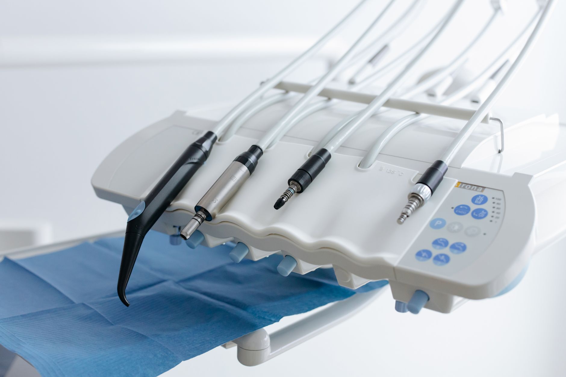 Close-up of advanced dental tools and sterilisation equipment on a blue surface.