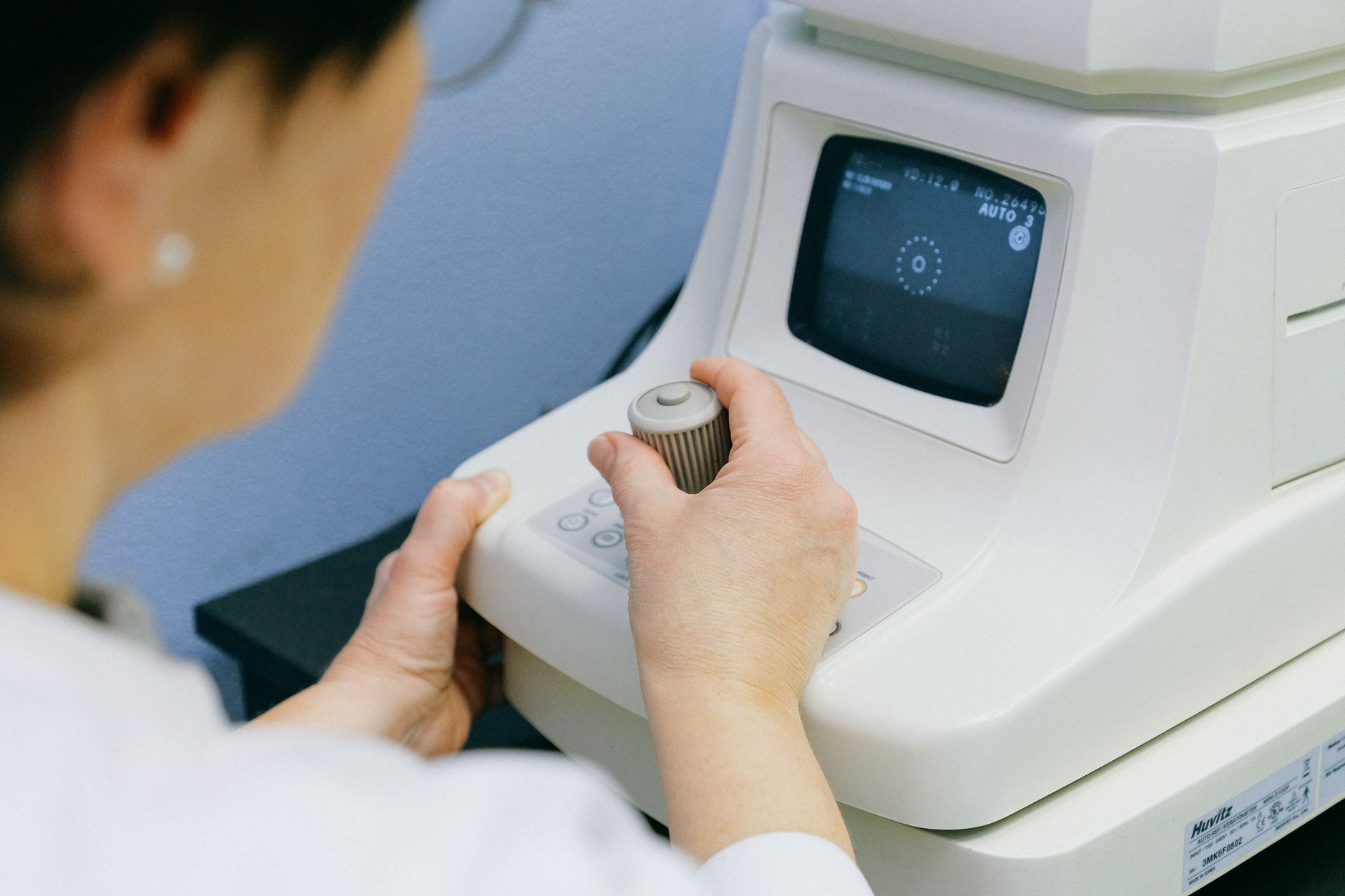 Close-up of a neurologist programming a deep brain stimulation device in a clinical setting.