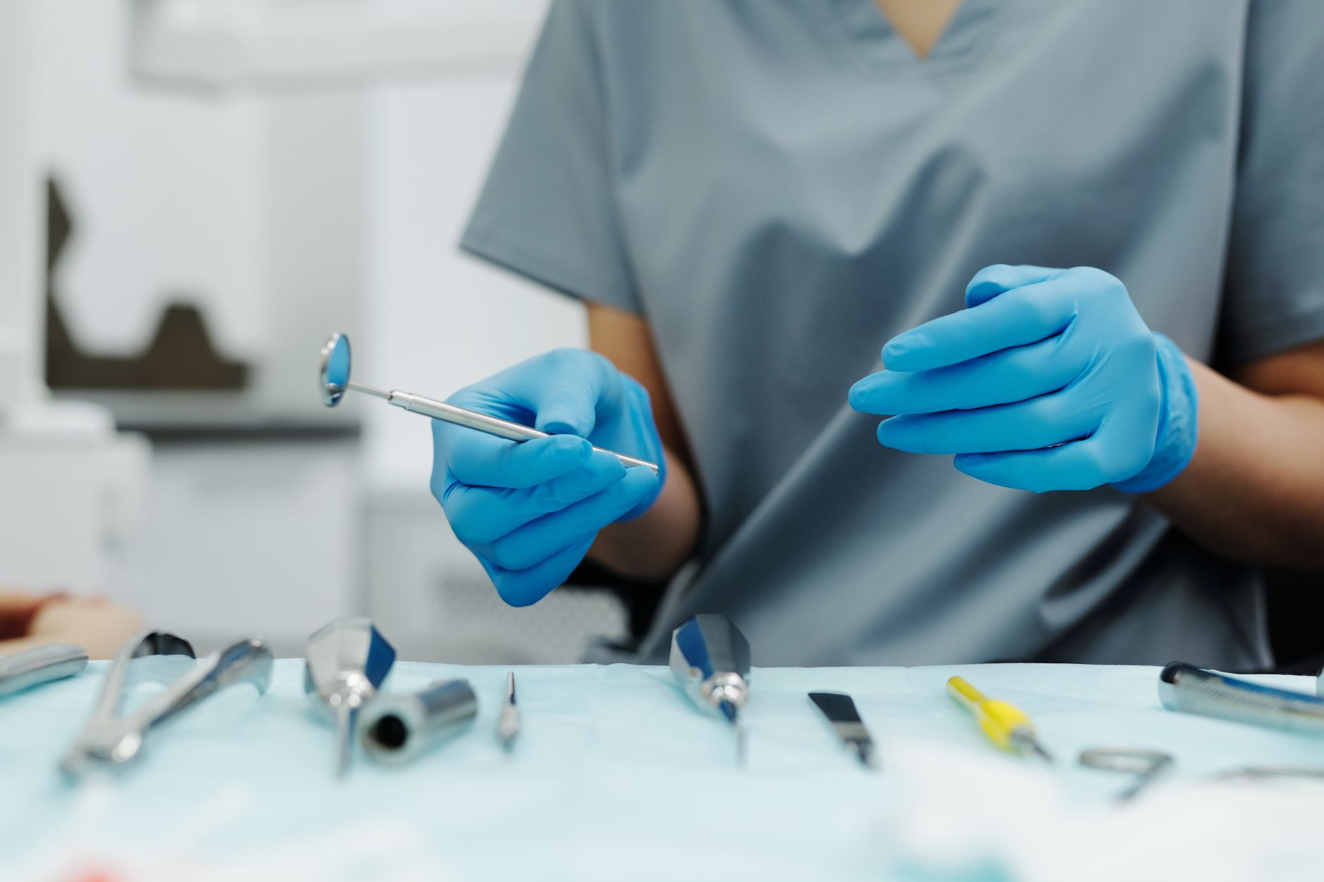 Close-up of a dentist's hands with tools in a modern dental office.