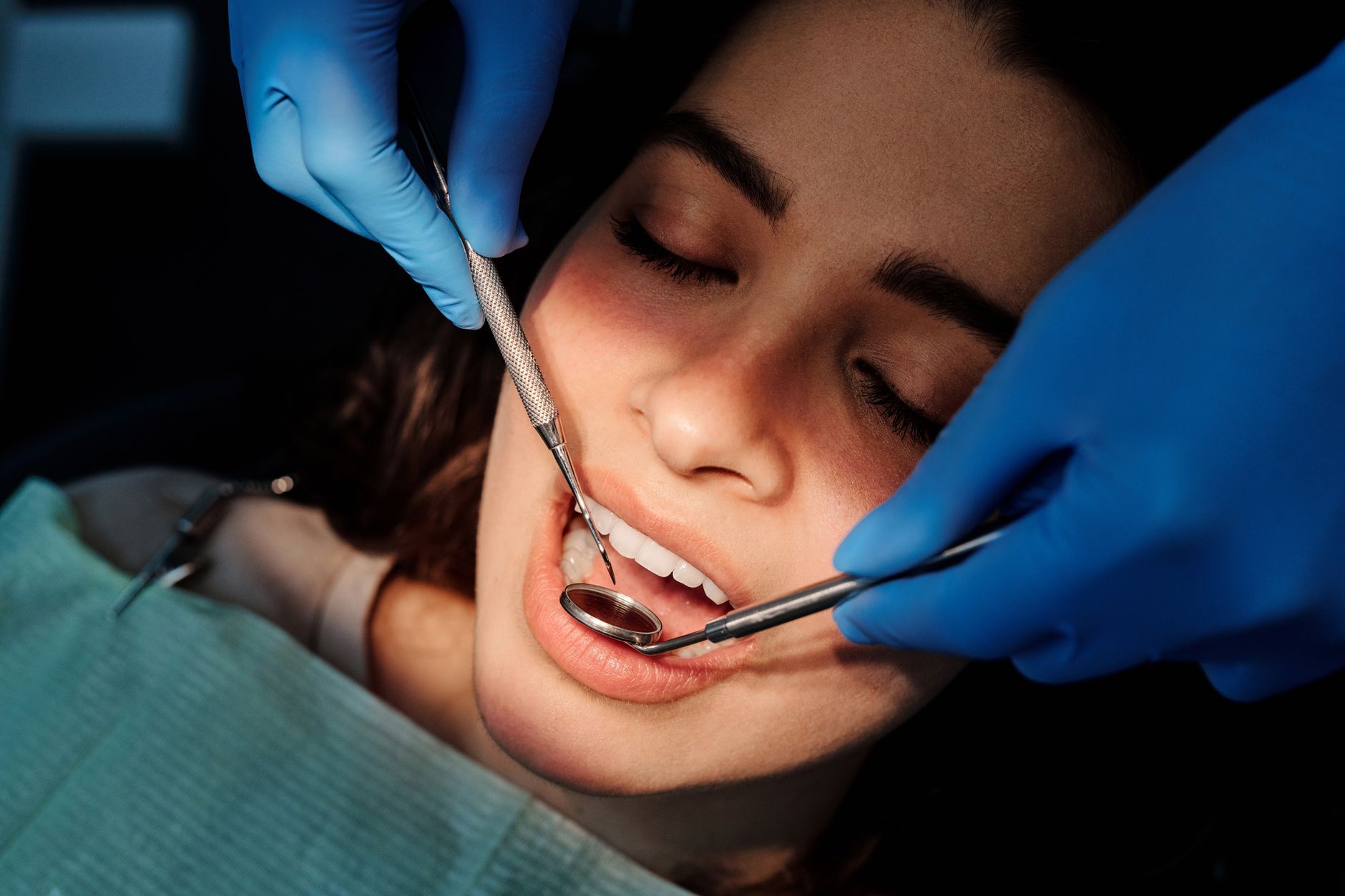 A patient being examined at a dental clinic, smiling with healthy teeth.