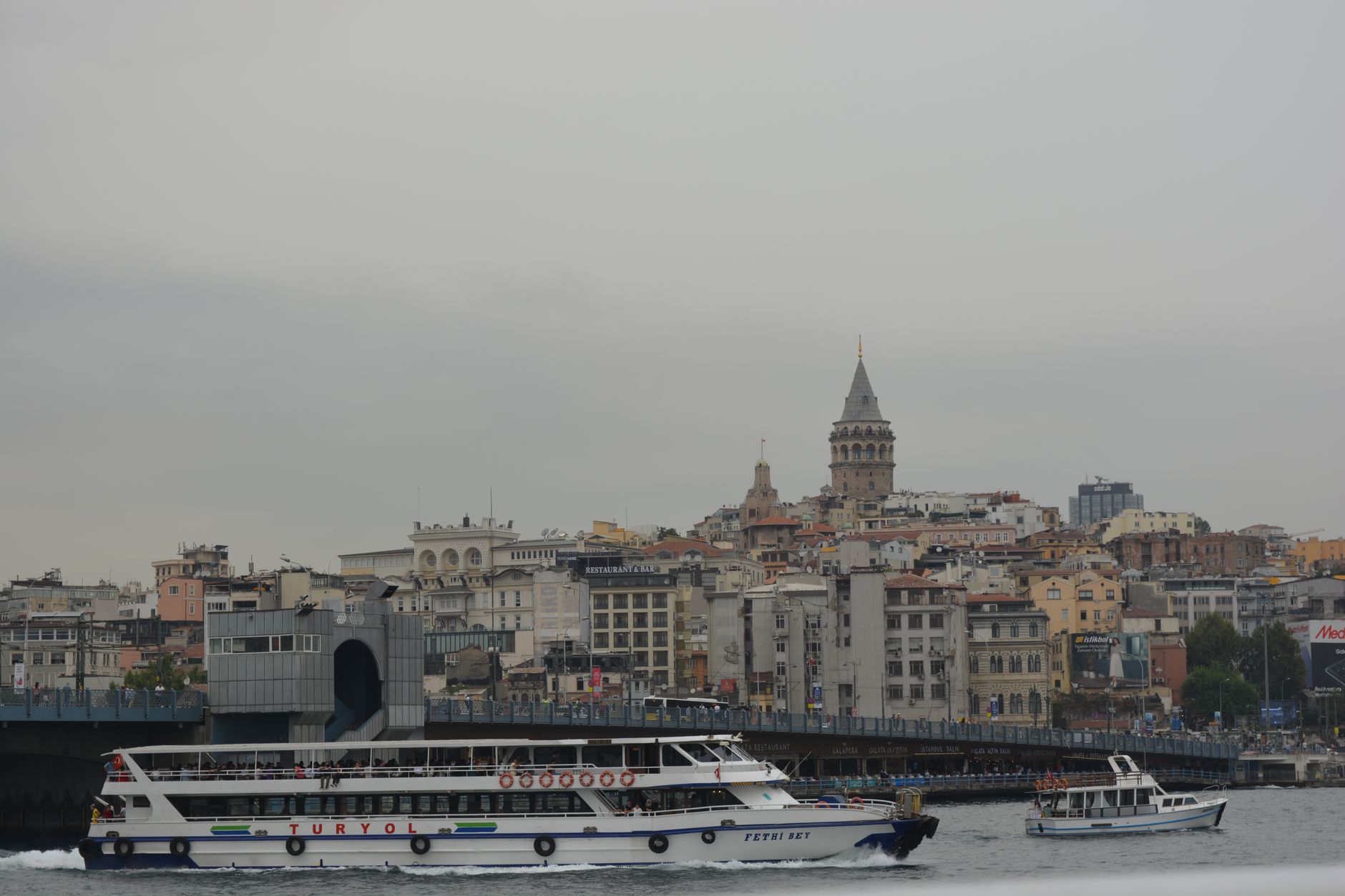View of Istanbul skyline featuring Galata Tower, boats on Bosphorus, capturing the essence of travel and dental trips.