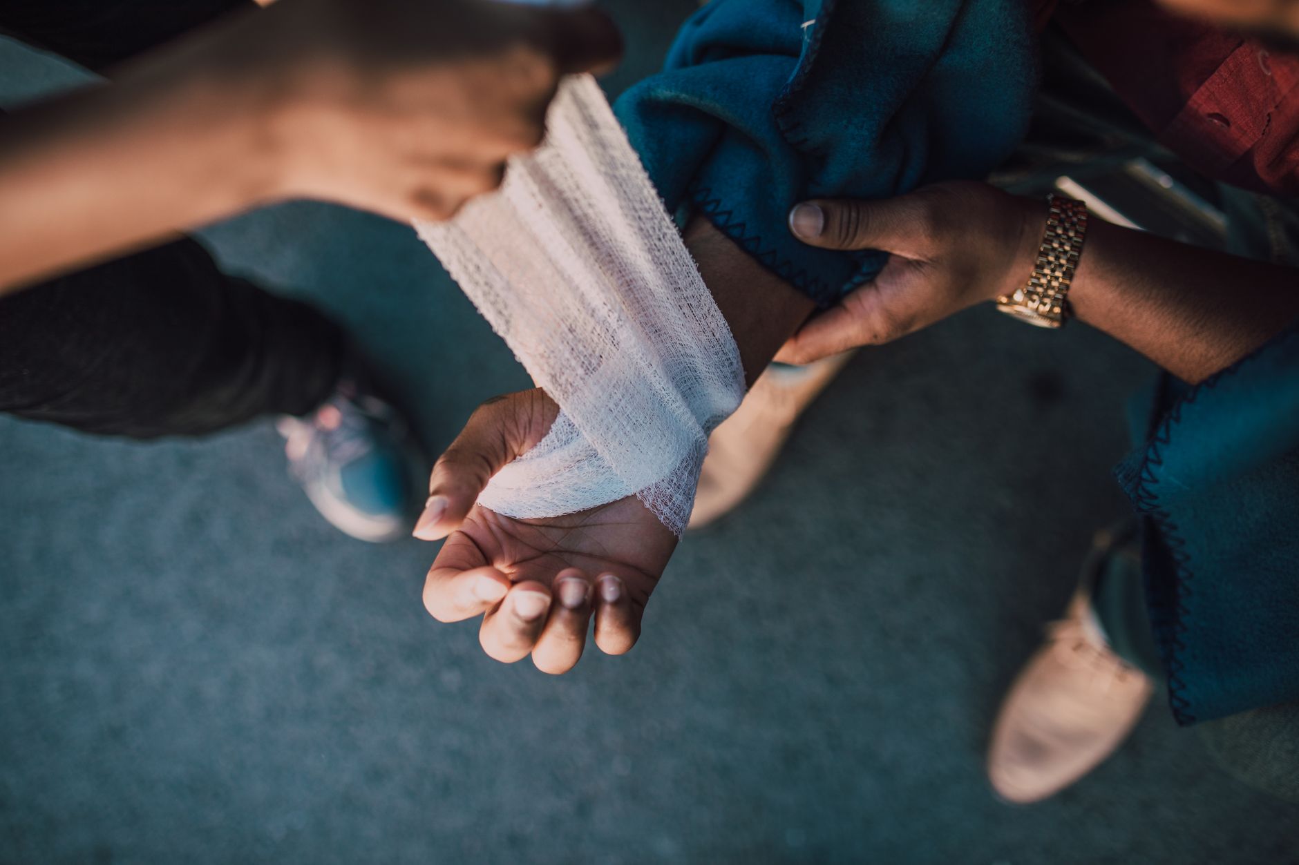 A nurse wraps a bandage around a patient's wrist, providing care.