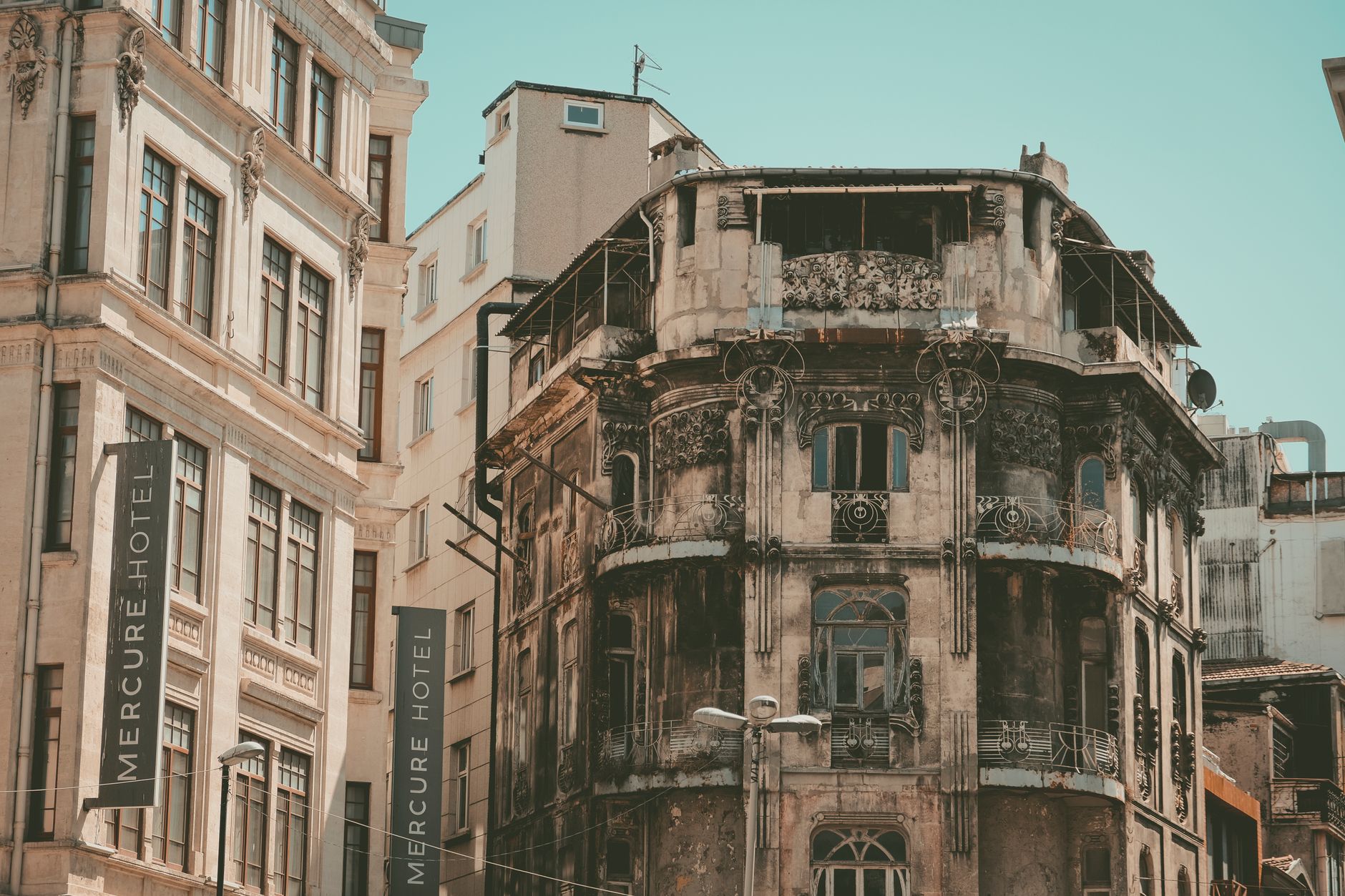 Facade of an old building next to Mercure Hotel in Istanbul, showcasing intricate design and weathered aesthetics.