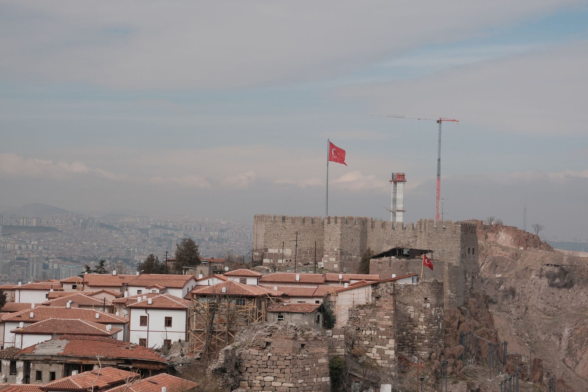 View of a historic fortress in Ankara, Turkey, with red-roofed houses below.