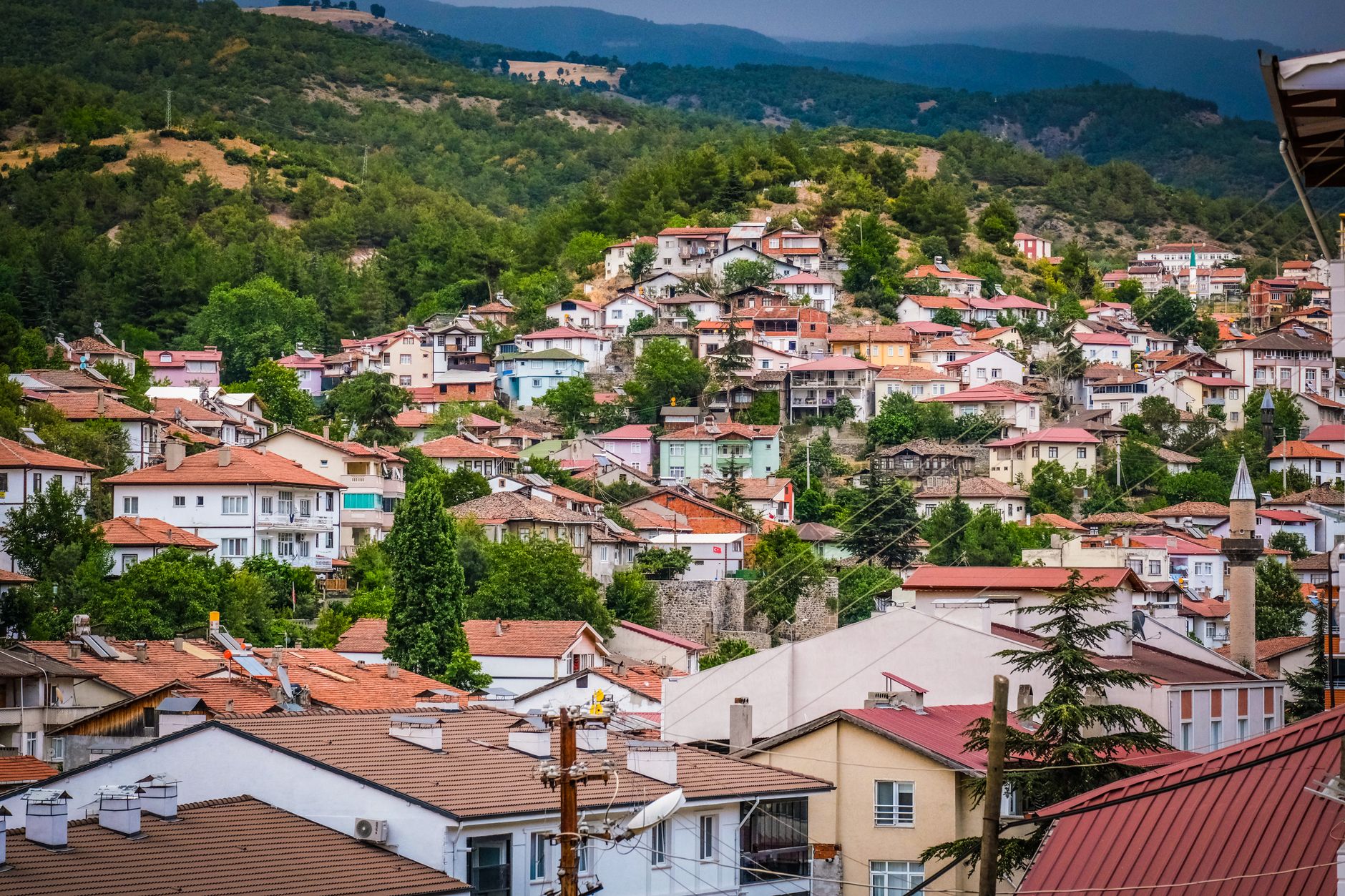 A scenic view of Eğirdir old town featuring colorful Ottoman houses on a hillside.