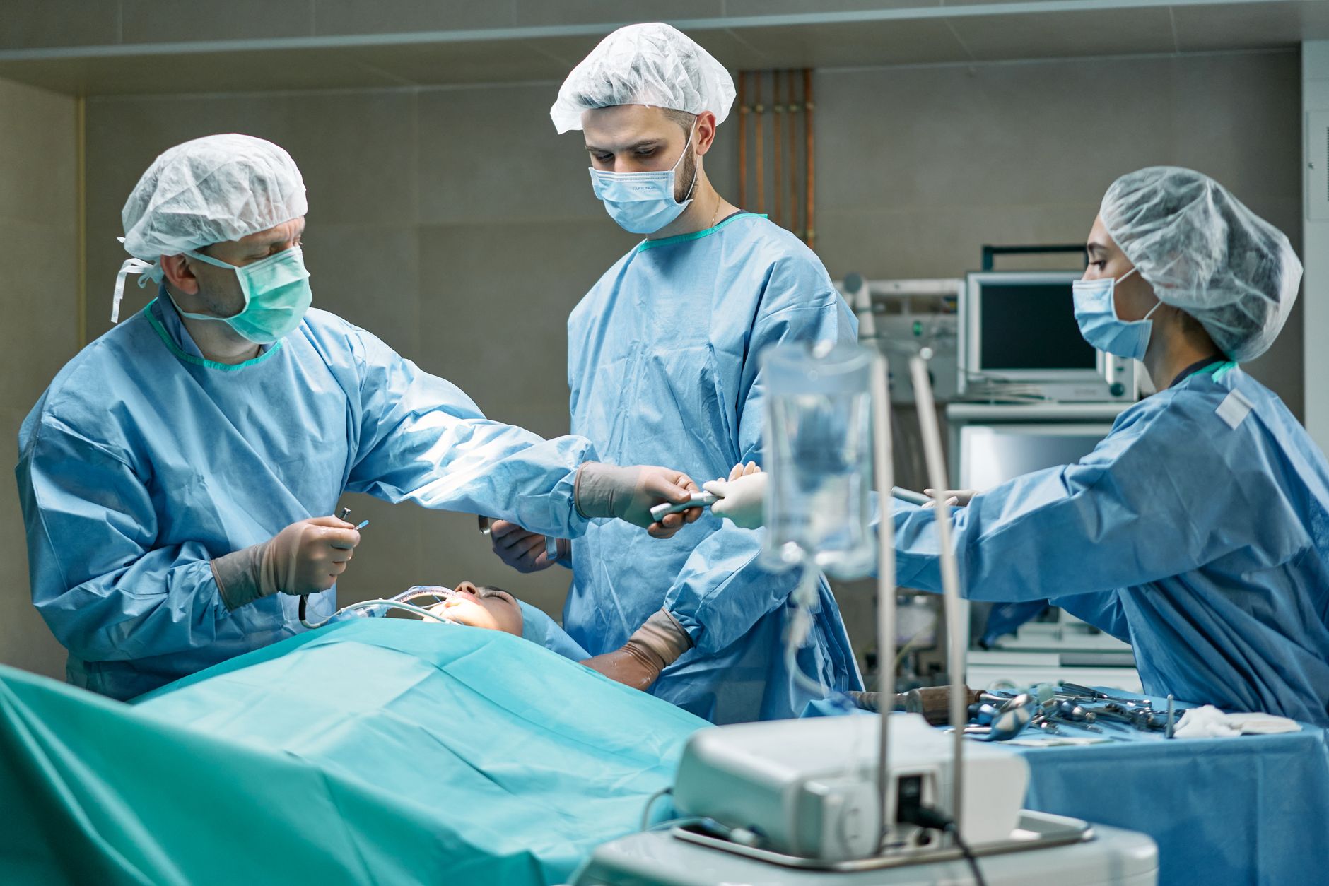 A skilled surgical team working diligently on a patient in an operating room.