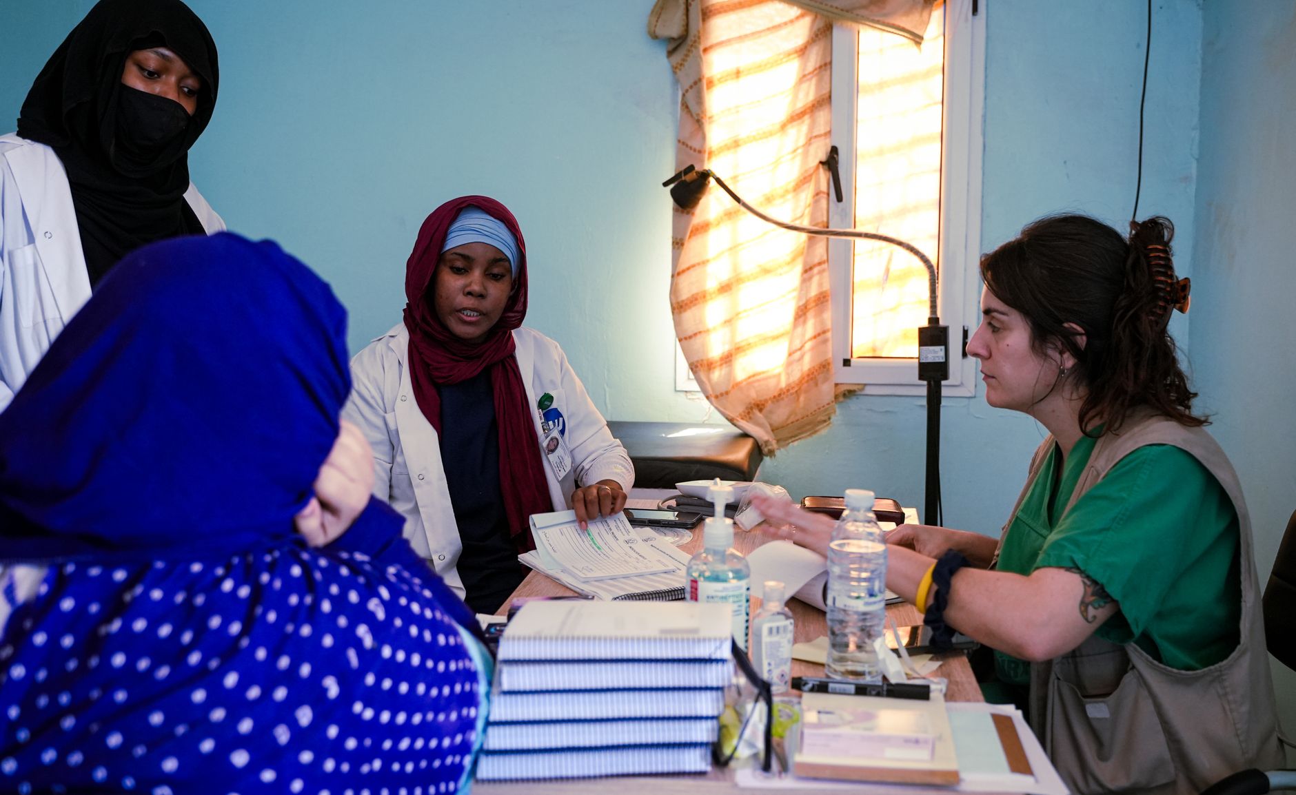 Healthcare professionals in a consultation session with a patient, discussing medical care in a cross-border context.
