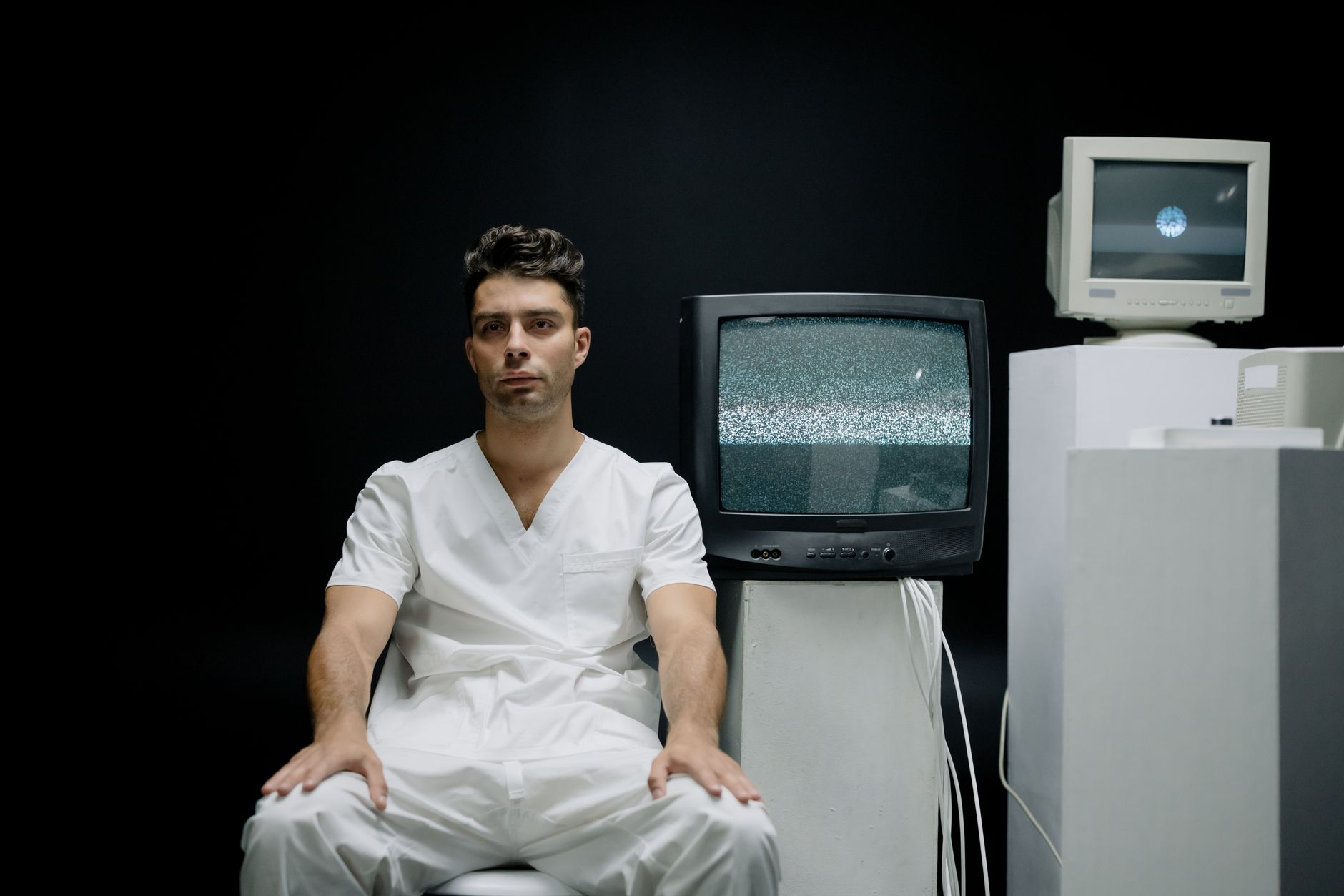 A patient in a hospital bed with EEG electrodes being monitored by a neurologist.
