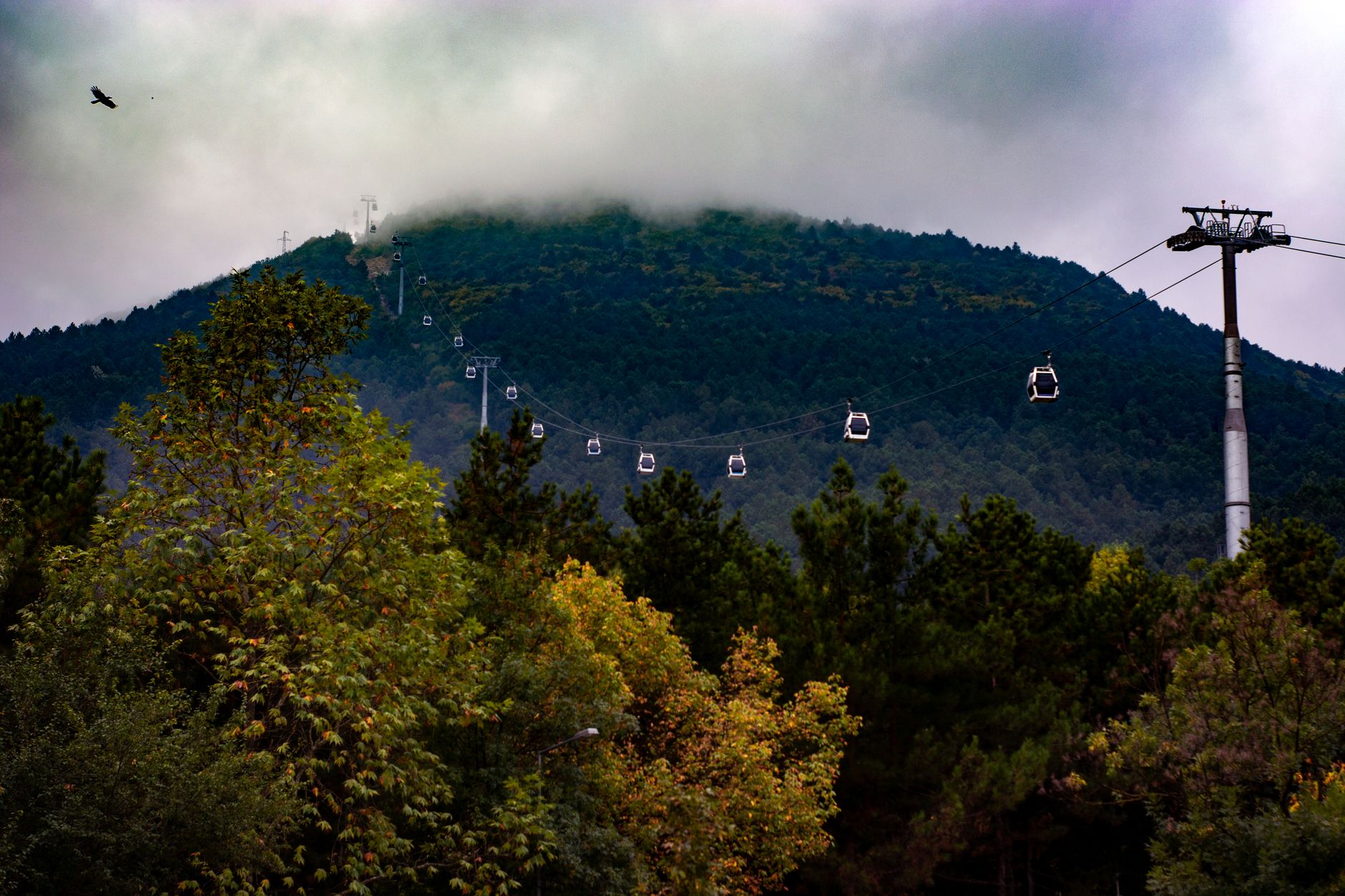 Cable car cabins traversing Uludağ Mountain amidst cloudy skies.