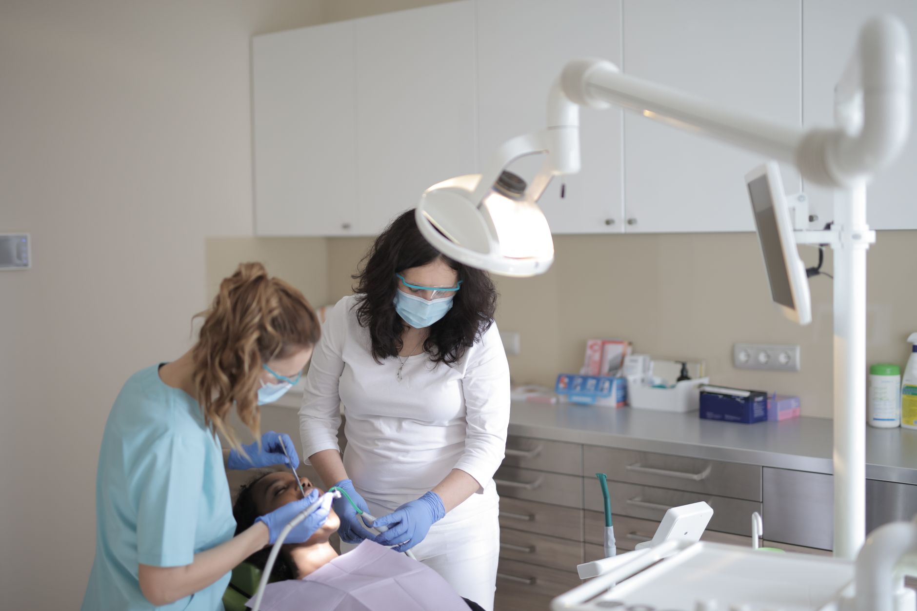 Two dental professionals assist an international patient in a modern dental office in Kocaeli.