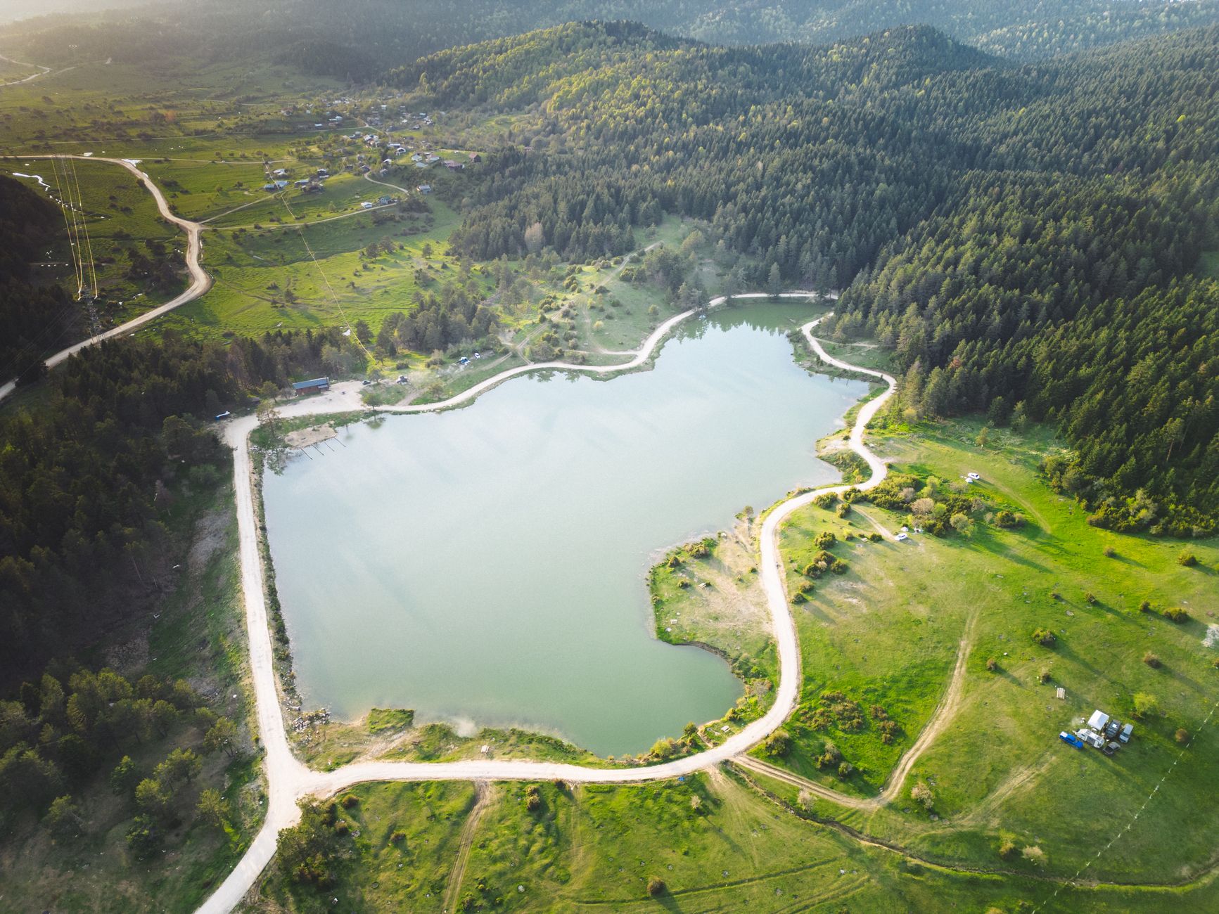 A tranquil lake in Sakarya, bordered by dense green forest, ideal for relaxation.