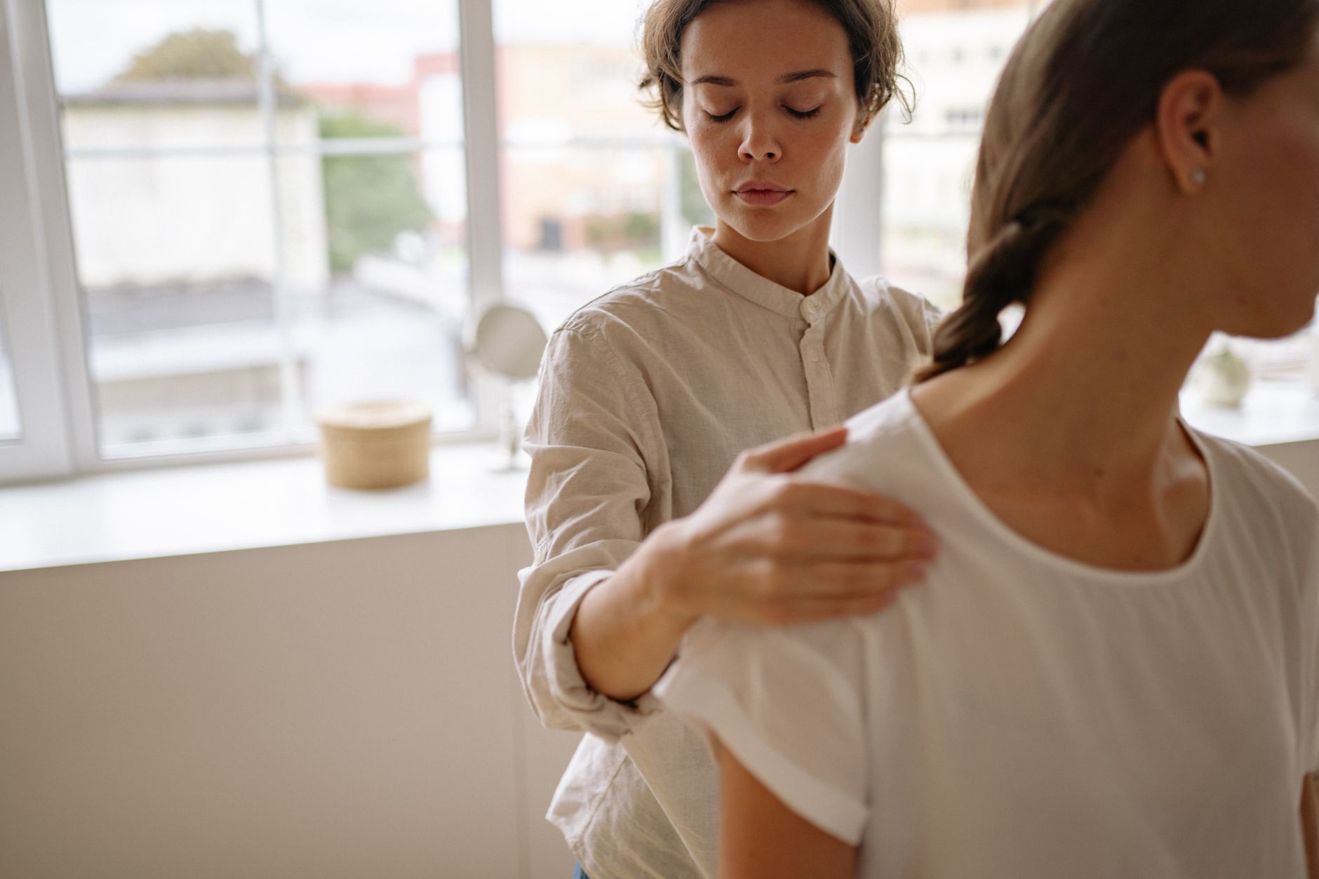 A therapist guides a patient during a facial rehabilitation session, focusing on post-surgery recovery.
