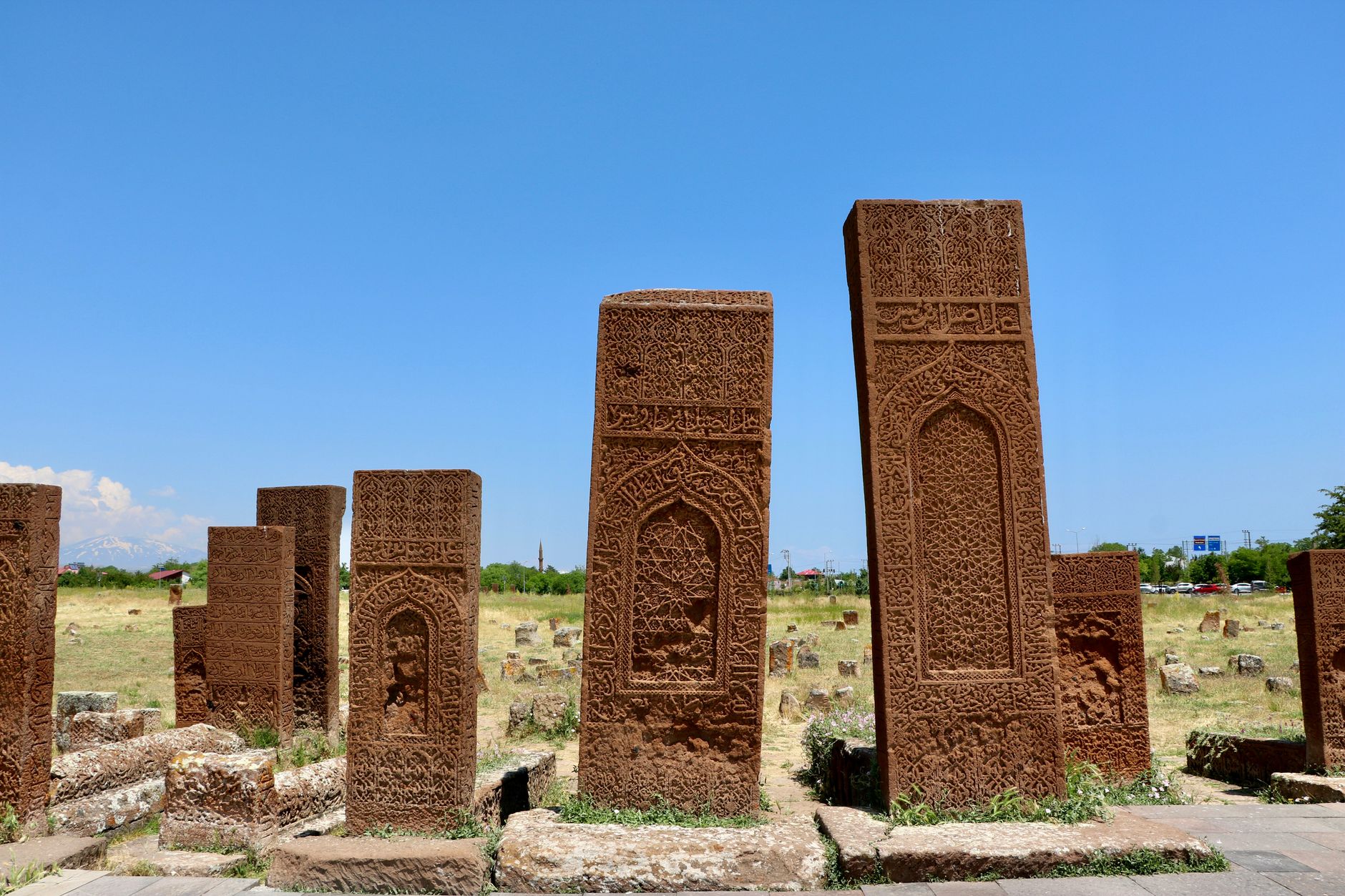 Historic Seljuk-era stone carvings standing in a grassy field in Feke, Turkey.