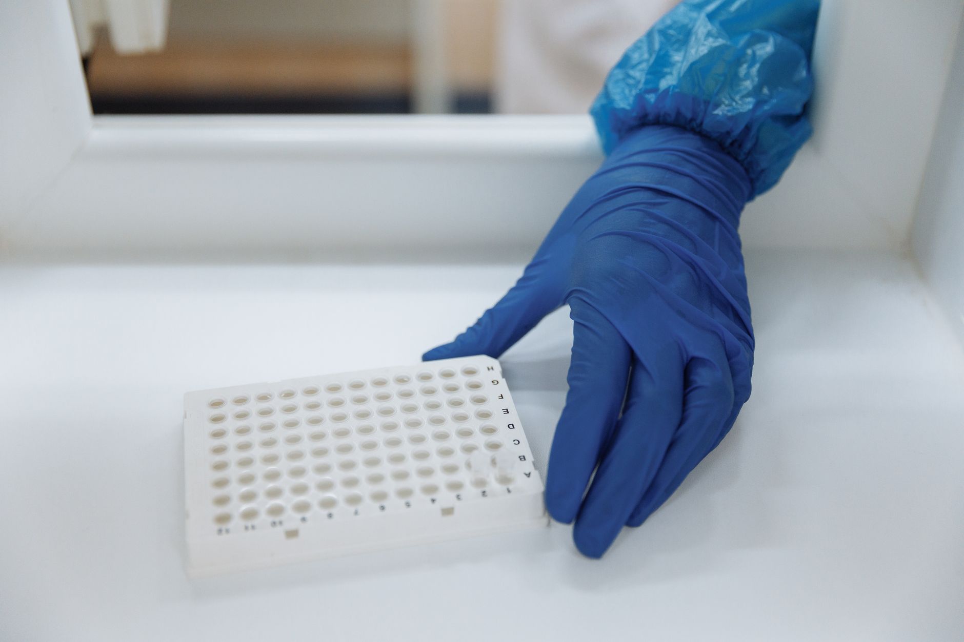 A laboratory technician in blue gloves preparing cryopreservation vials for egg, sperm, and tissue freezing.